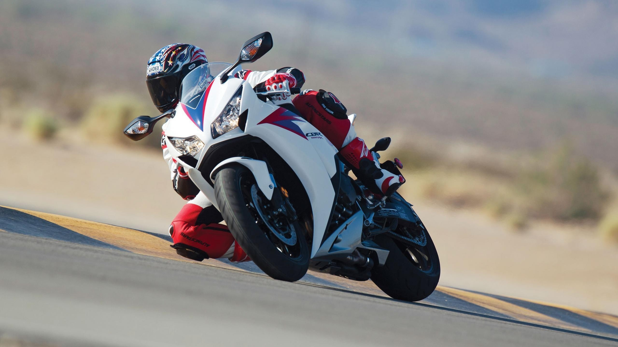 Homme en Costume de Moto Blanc et Noir Faisant du Vélo de Sport. Wallpaper in 2560x1440 Resolution