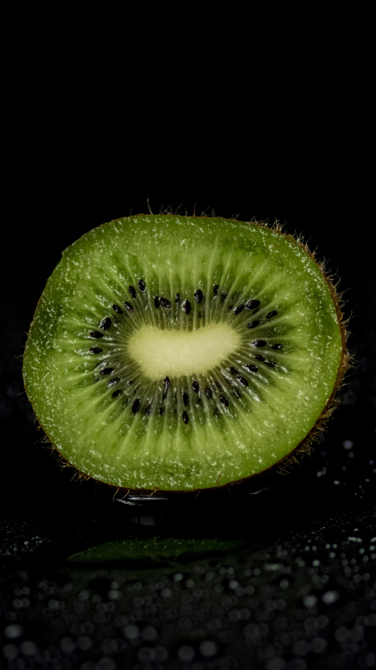 Fruta Redonda Verde Sobre Superficie Negra. Wallpaper in 750x1334 Resolution