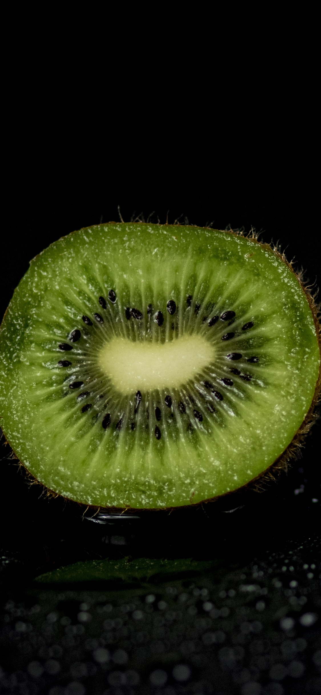 Green Round Fruit on Black Surface. Wallpaper in 1125x2436 Resolution