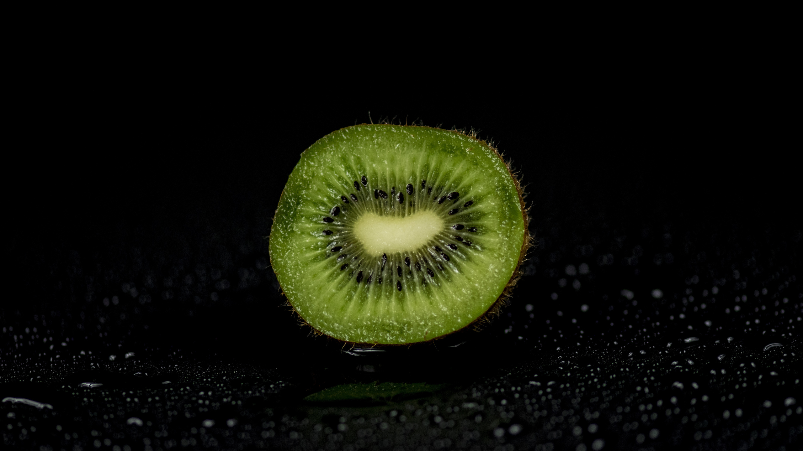 Green Round Fruit on Black Surface. Wallpaper in 2560x1440 Resolution