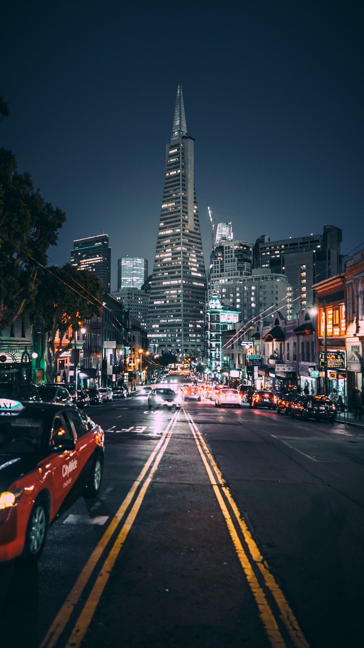 Autos Auf Der Straße in Der Nähe Von Hochhäusern Während Der Nacht. Wallpaper in 720x1280 Resolution