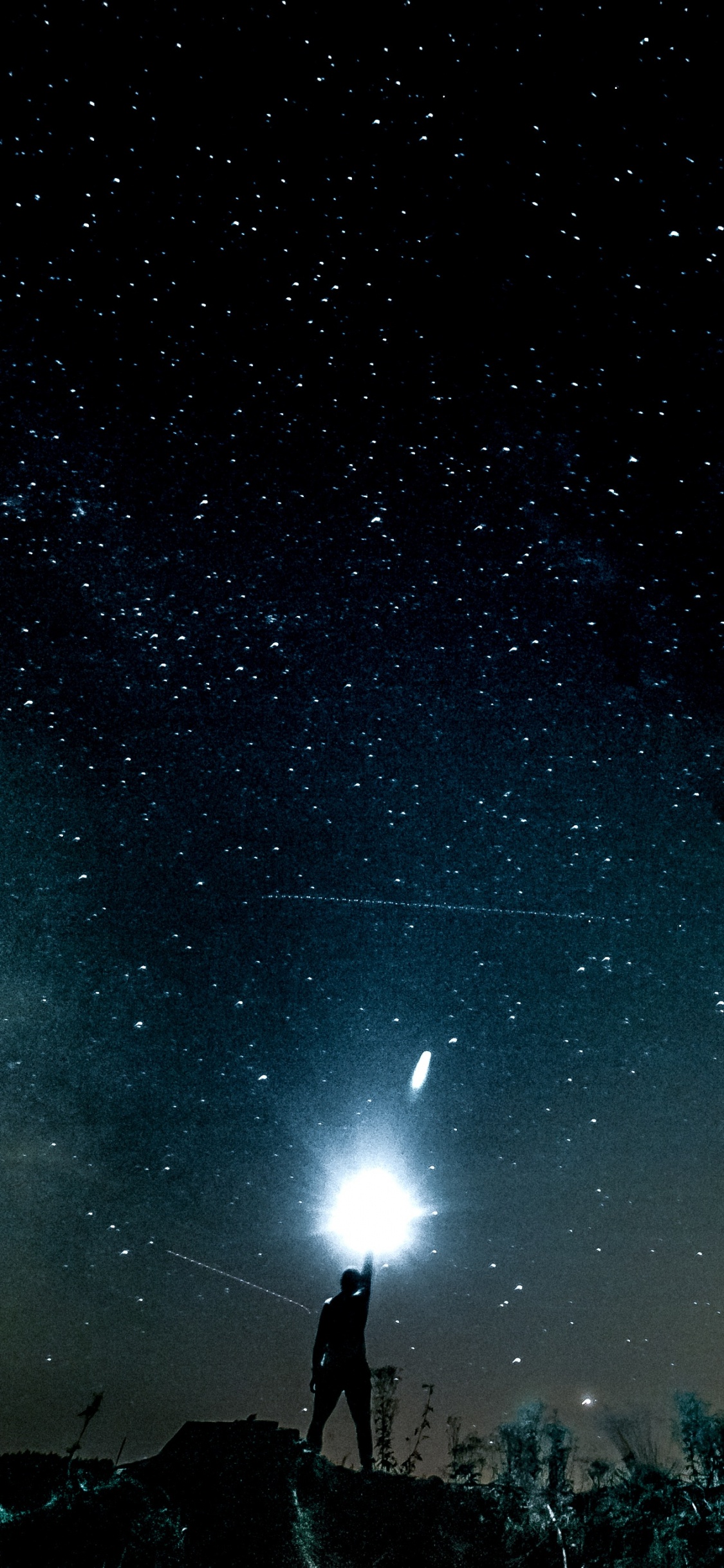 People Standing Under Starry Night. Wallpaper in 1125x2436 Resolution