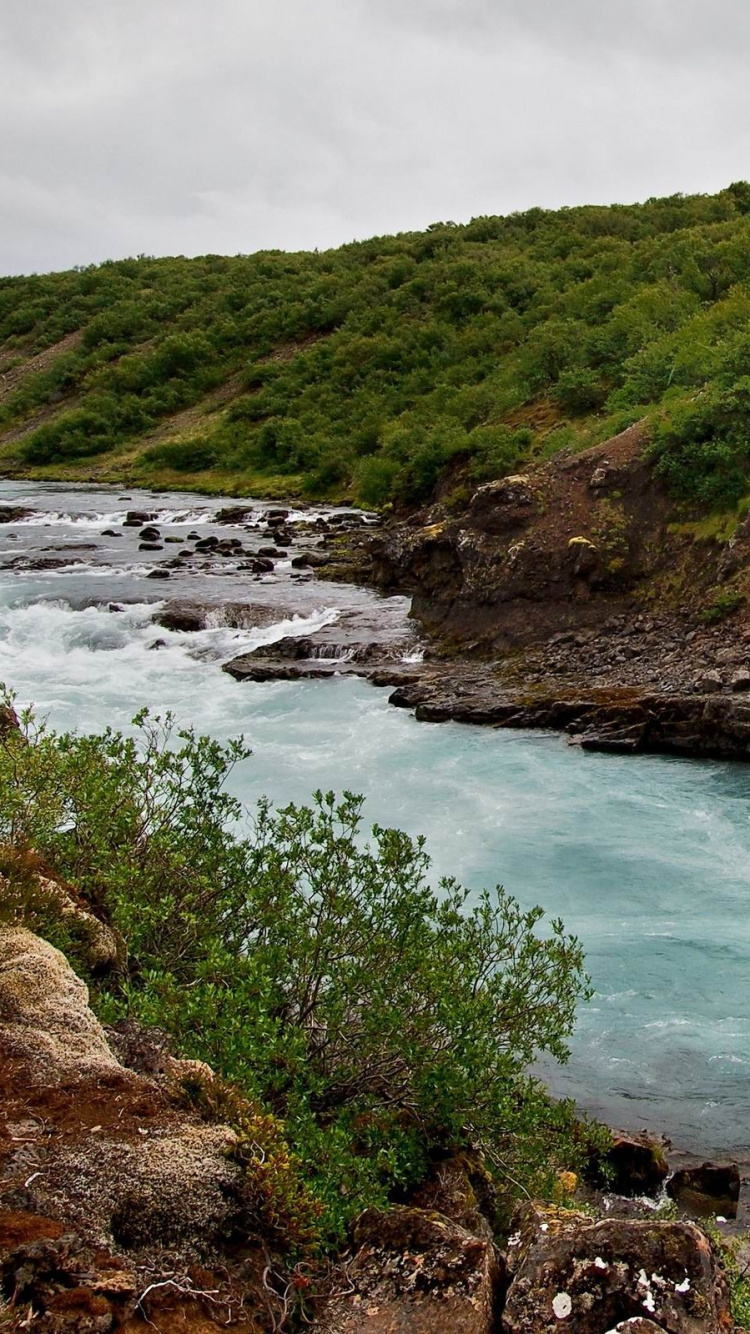 Montaña Verde y Marrón Junto al Cuerpo de Agua Durante el Día.. Wallpaper in 750x1334 Resolution