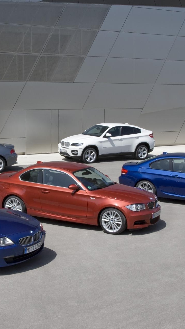 Blue Bmw Coupe Parked Beside White Sedan. Wallpaper in 720x1280 Resolution