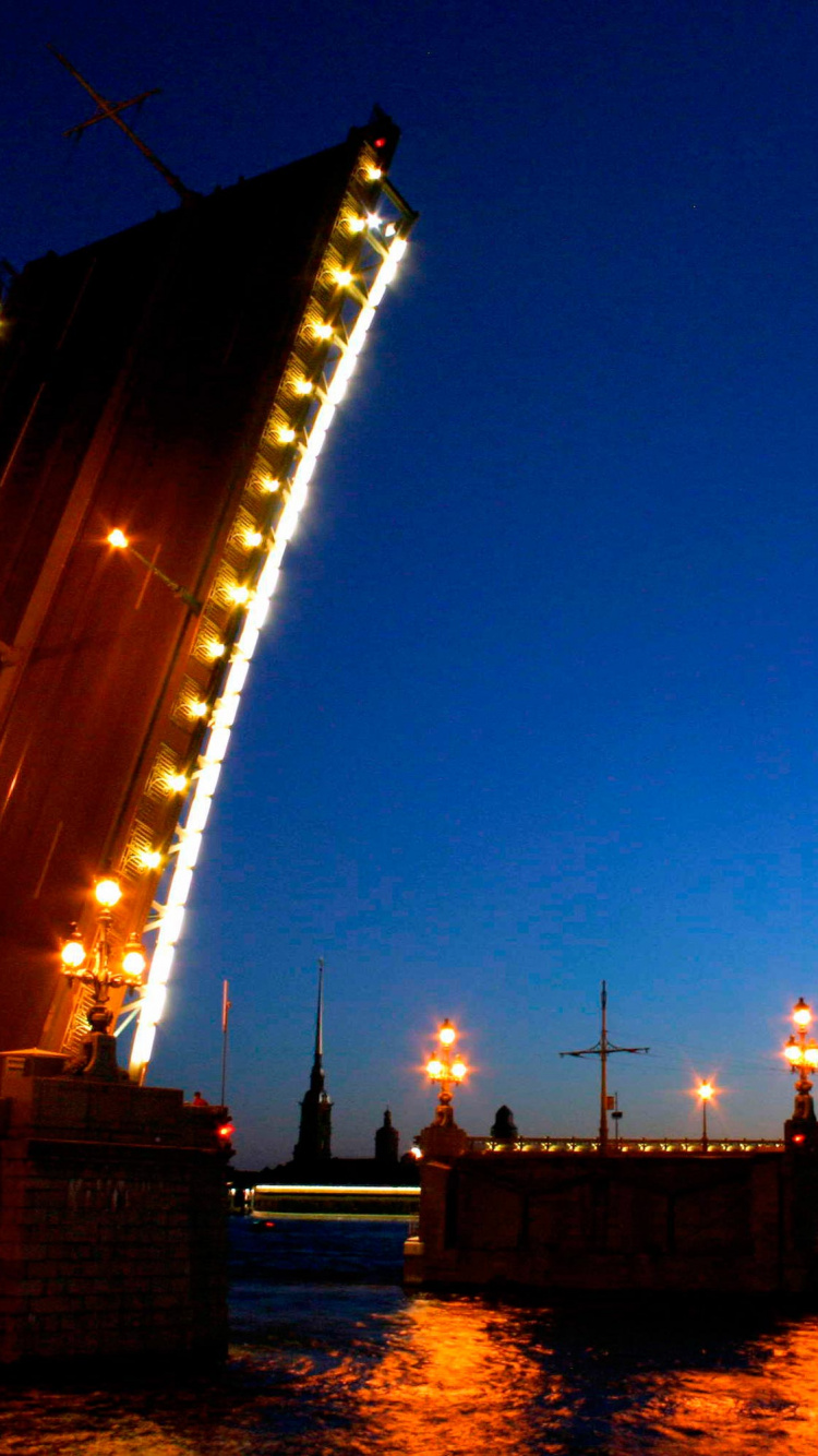 Puente Iluminado Sobre el Cuerpo de Agua Durante la Noche. Wallpaper in 750x1334 Resolution