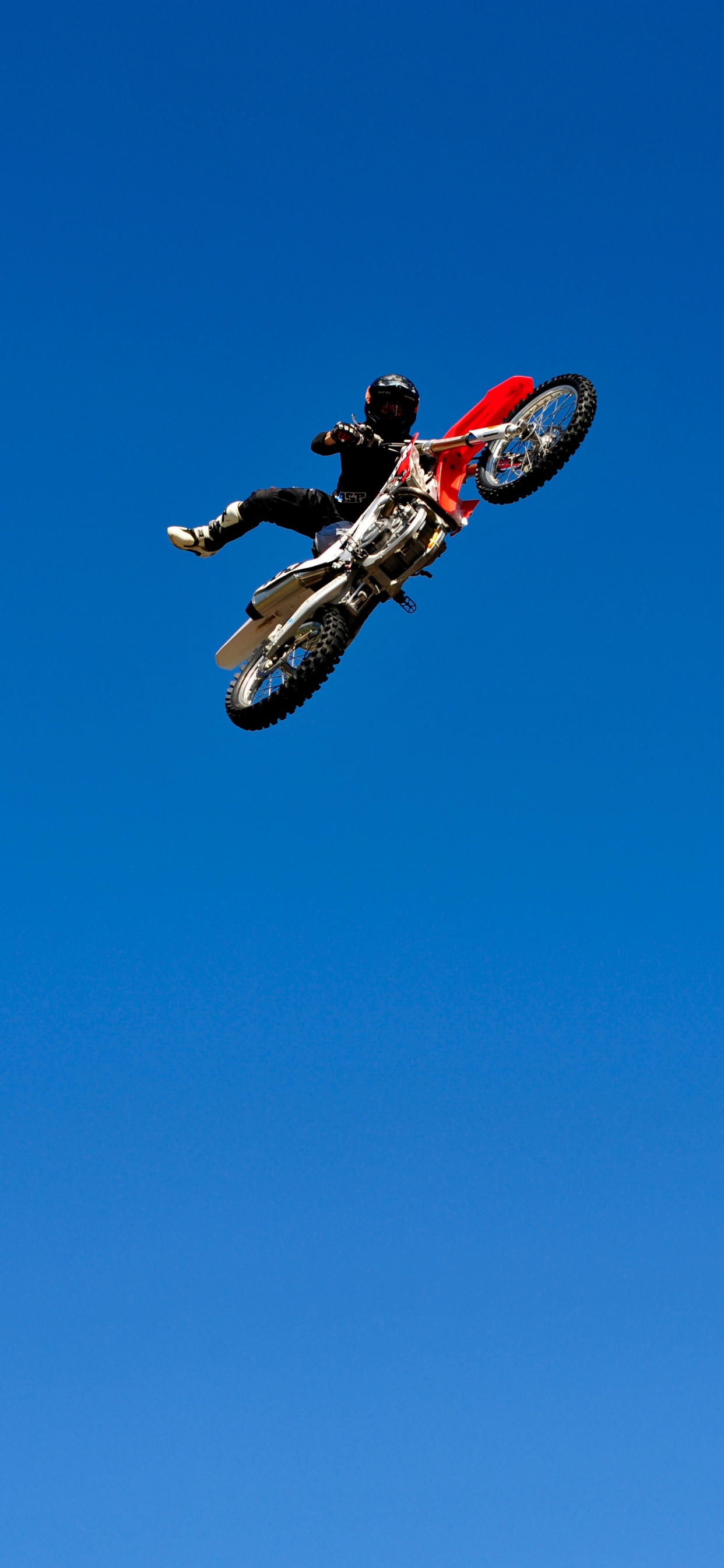 Man in Red and Black Motocross Suit Riding Red and White Motocross Dirt Bike. Wallpaper in 1242x2688 Resolution