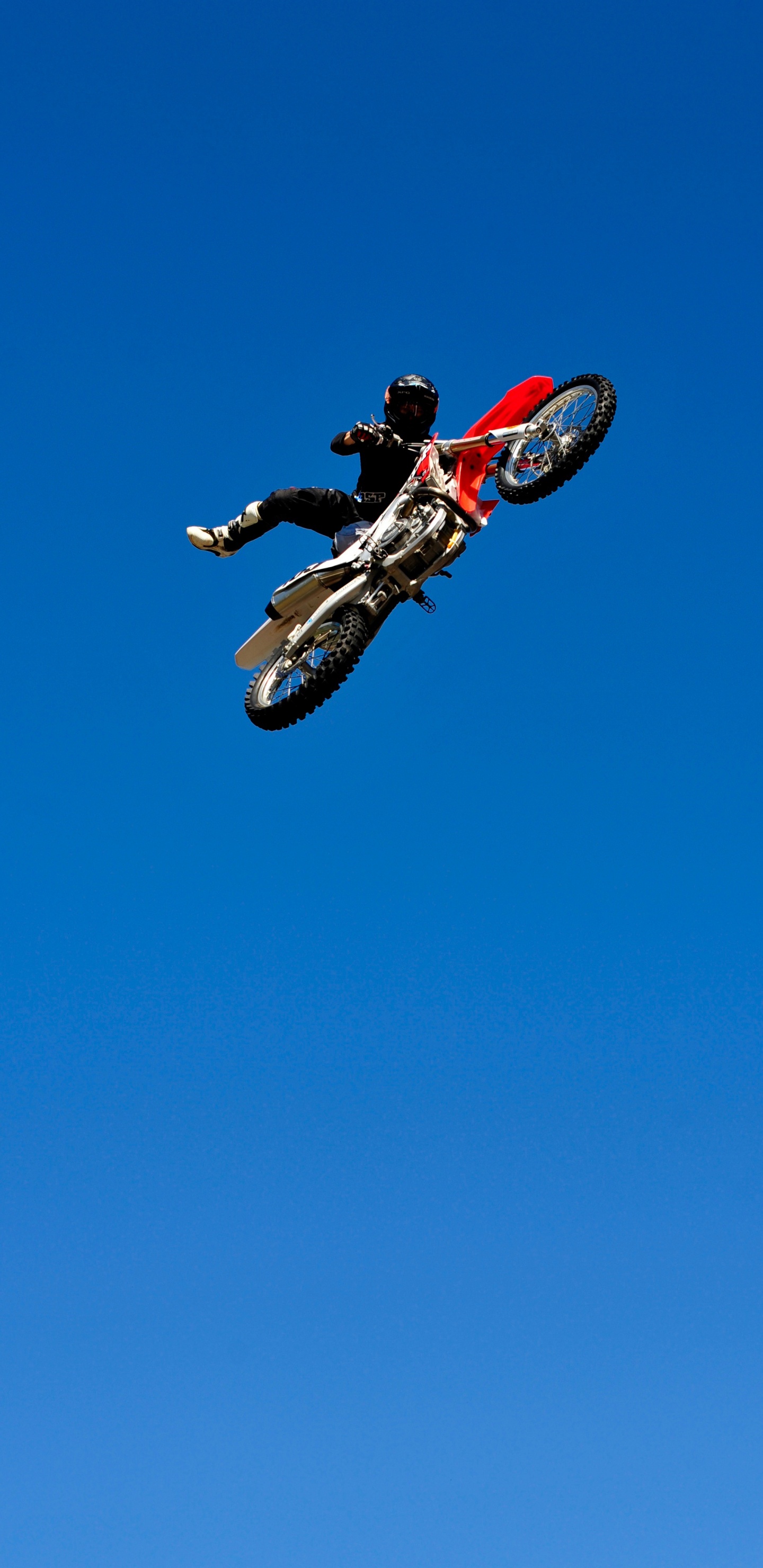 Man in Red and Black Motocross Suit Riding Red and White Motocross Dirt Bike. Wallpaper in 1440x2960 Resolution