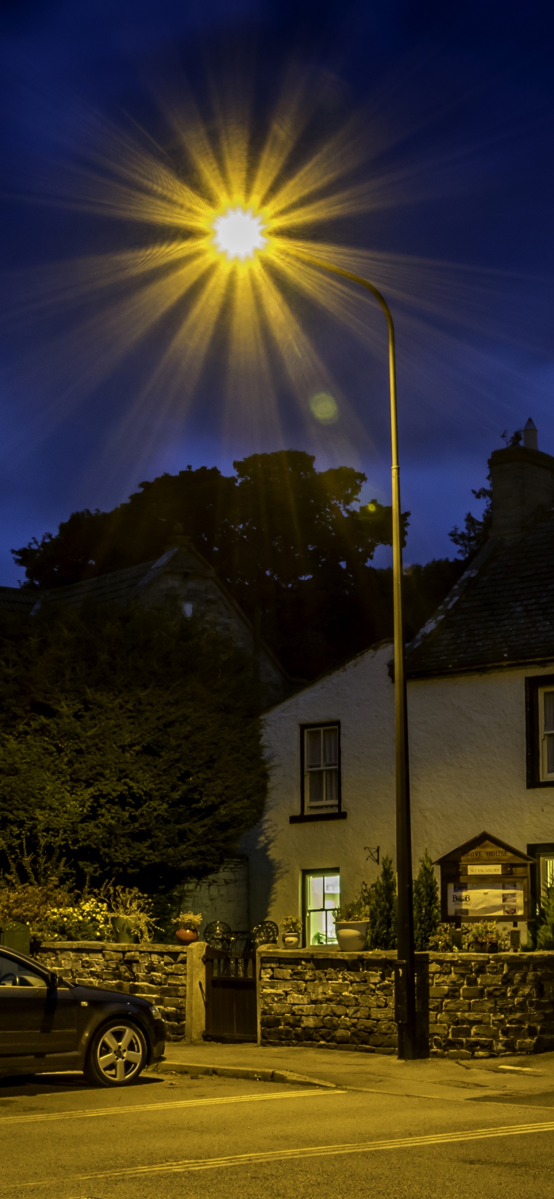 White and Brown Concrete House Near Gray Suv During Daytime. Wallpaper in 1125x2436 Resolution