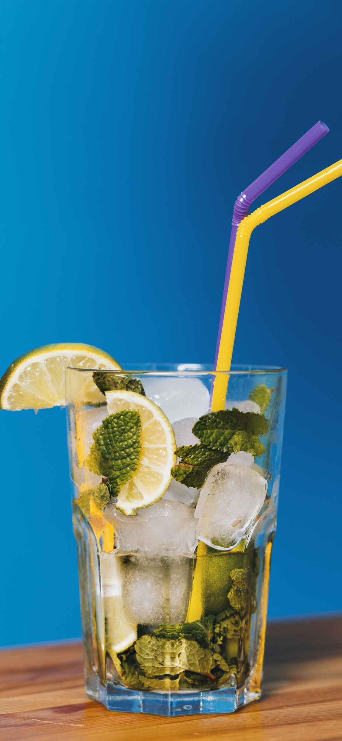 Clear Drinking Glass With Ice and Straw. Wallpaper in 1125x2436 Resolution