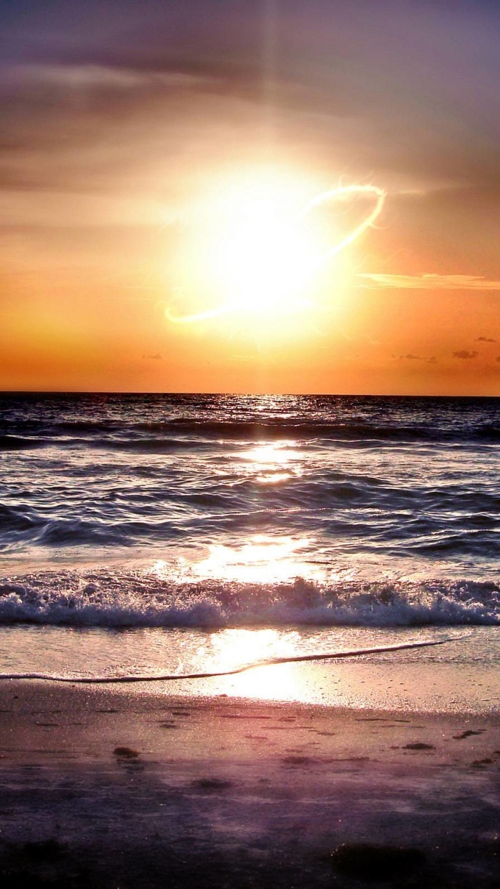 Sea Waves Crashing on Shore During Sunset. Wallpaper in 720x1280 Resolution