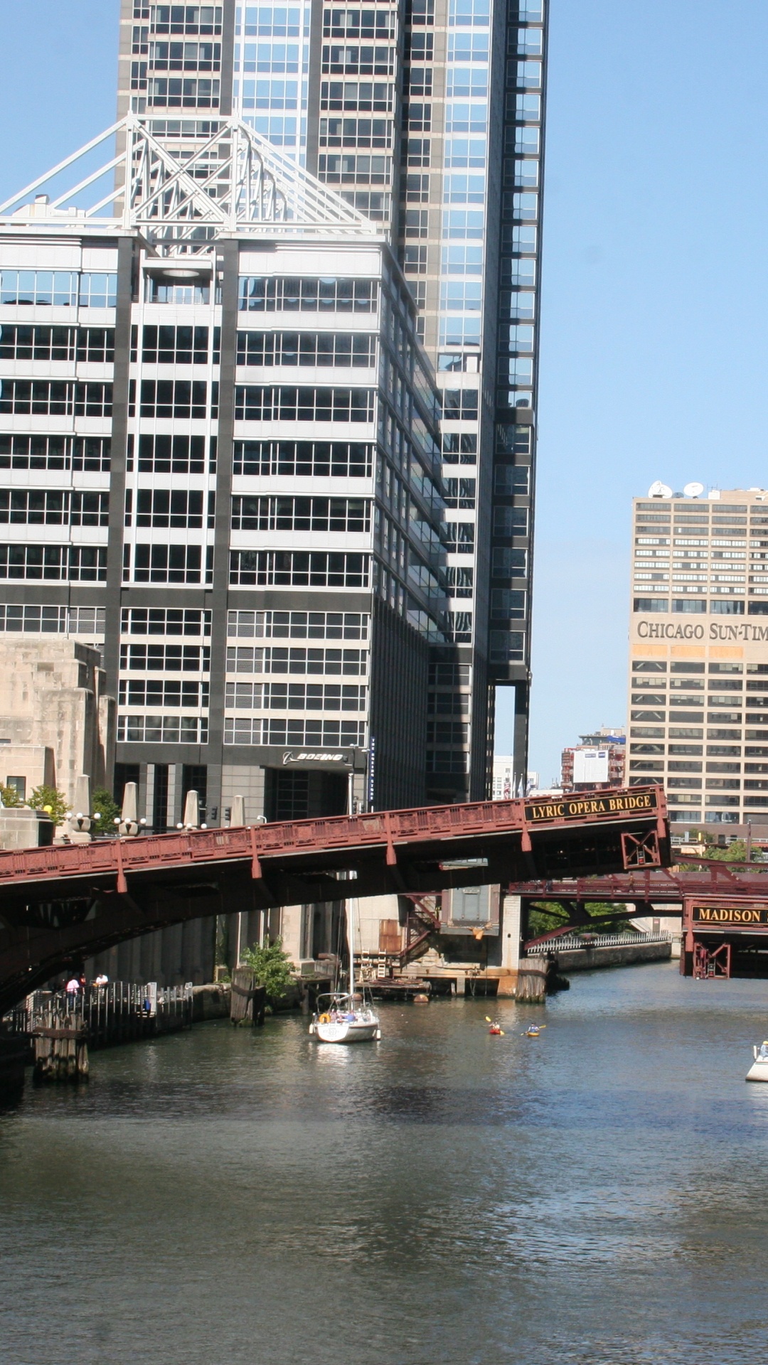 Brown Bridge Over River Near High Rise Buildings During Daytime. Wallpaper in 1080x1920 Resolution