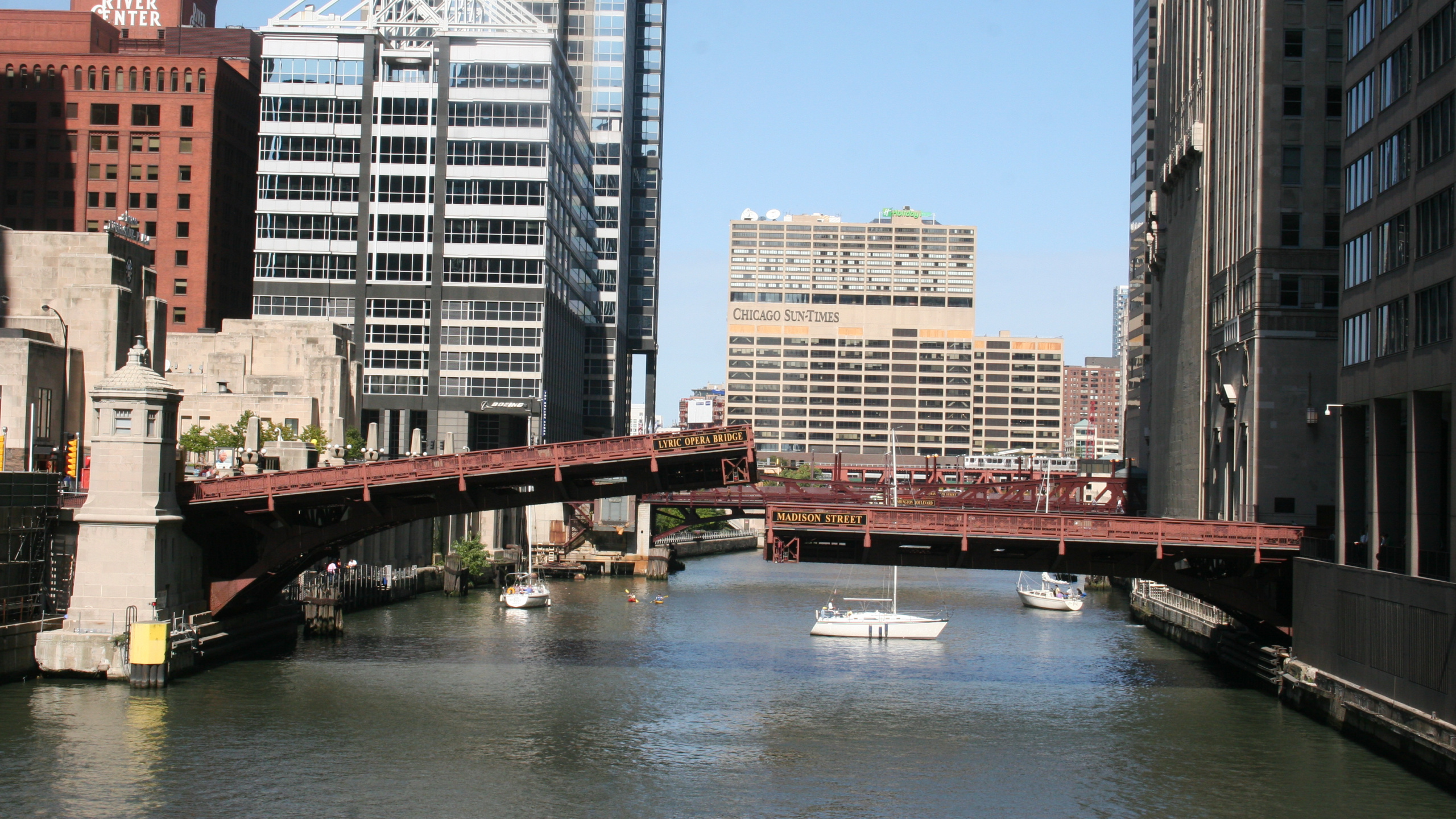 Brown Bridge Over River Near High Rise Buildings During Daytime. Wallpaper in 2560x1440 Resolution