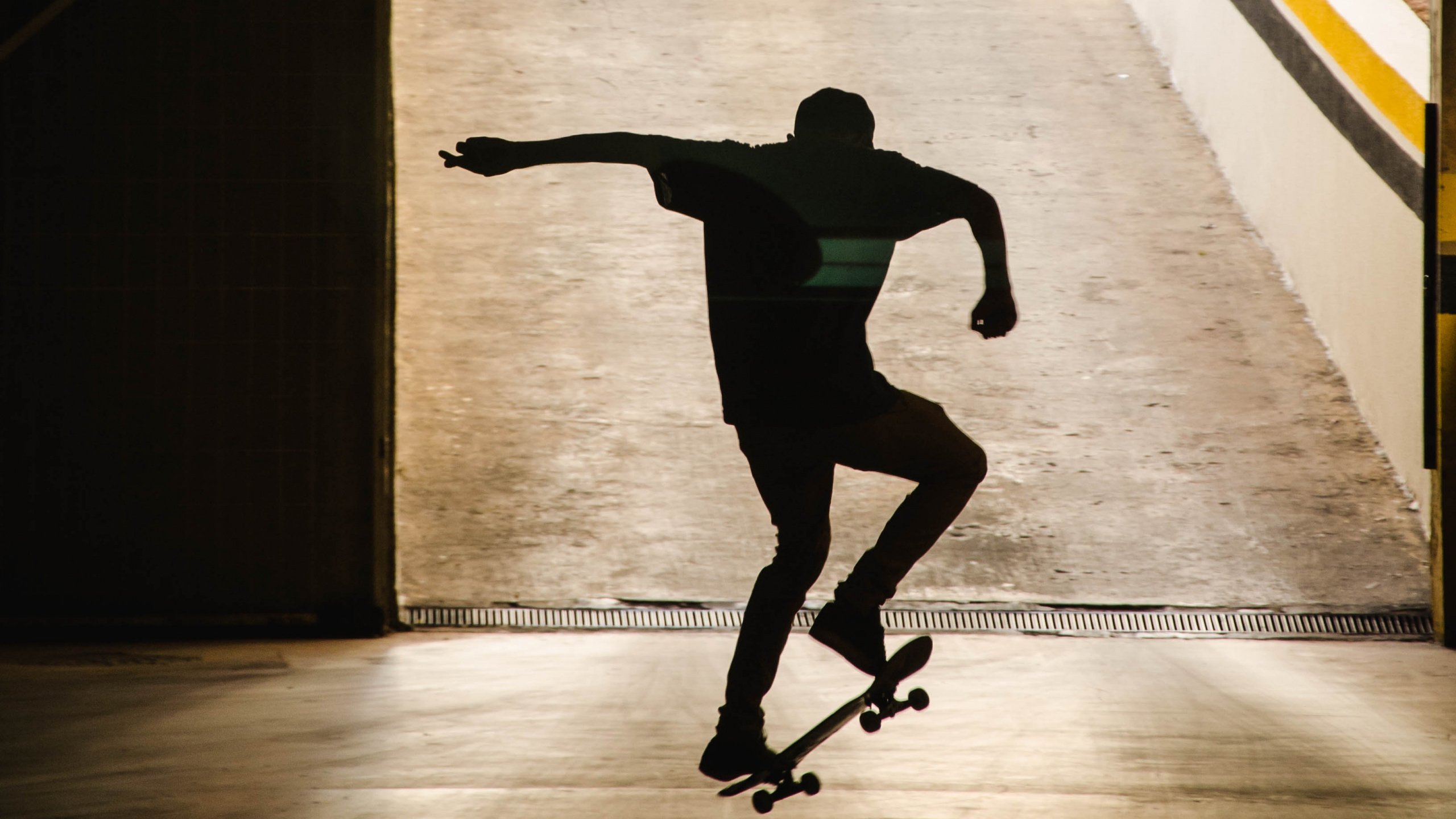Man in Black Shirt and Black Pants Jumping on Air. Wallpaper in 2560x1440 Resolution