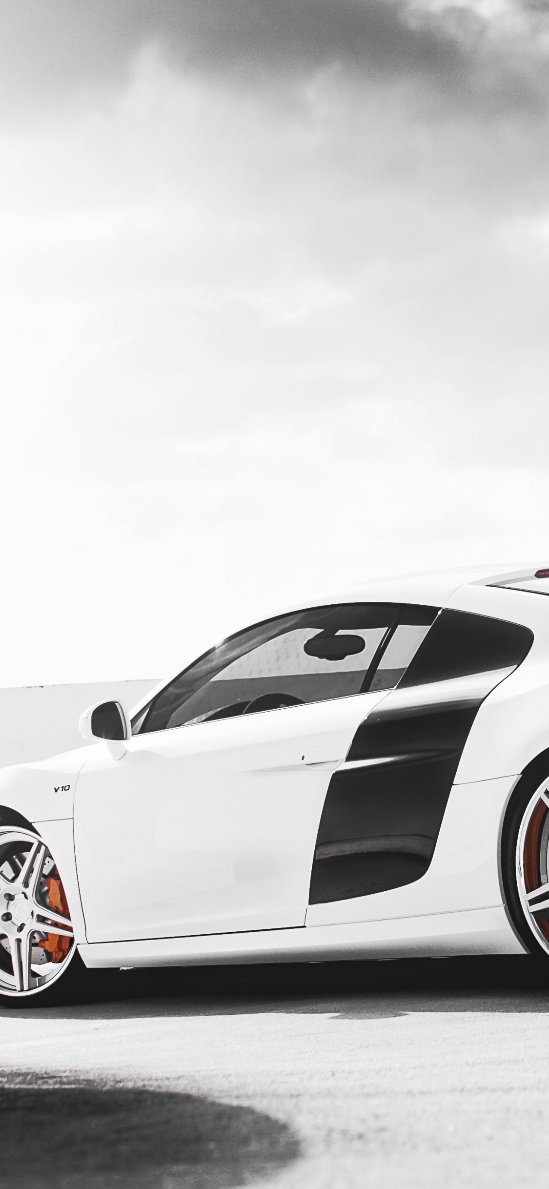 Porsche 911 Blanco Sobre Superficie Negra. Wallpaper in 1125x2436 Resolution