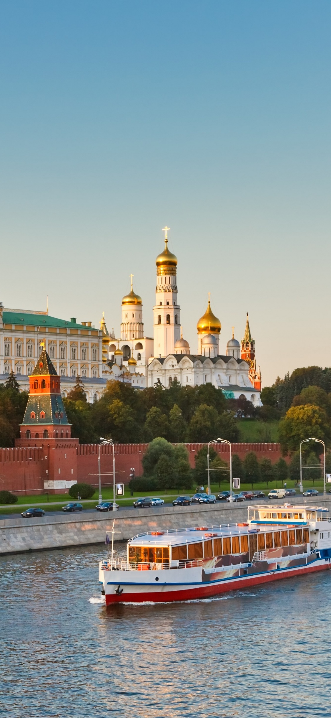 Weißes Und Rotes Boot Auf Dem Meer in Der Nähe Von Stadtgebäuden Tagsüber. Wallpaper in 1125x2436 Resolution