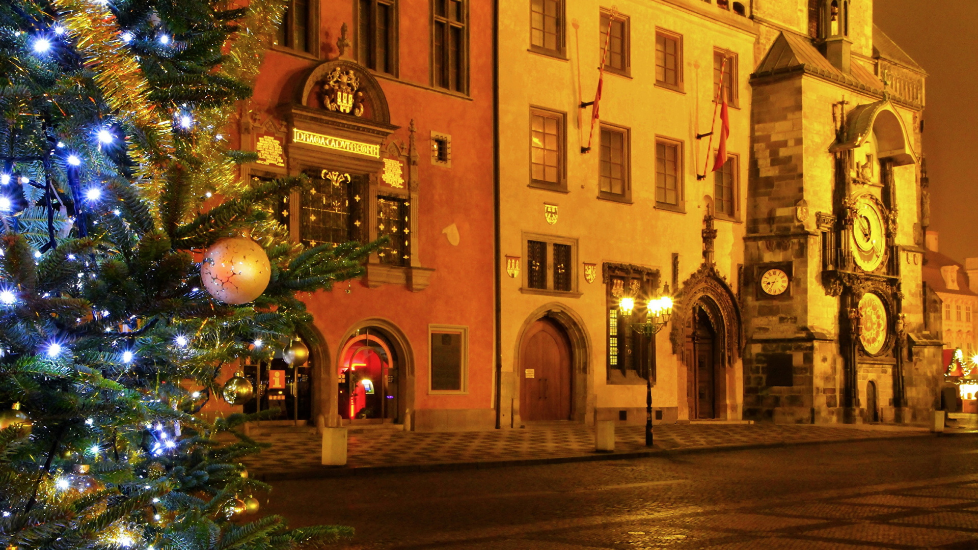 Árbol de Navidad Verde Con Luces de Cadena Cerca Del Edificio de Hormigón Marrón Durante la Noche. Wallpaper in 1920x1080 Resolution
