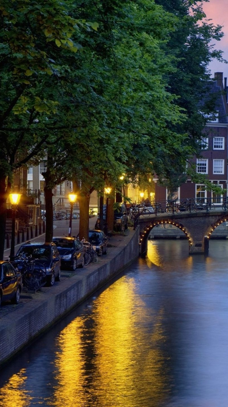 Personas Que Viajan en Bote Por el Río Durante la Noche.. Wallpaper in 750x1334 Resolution