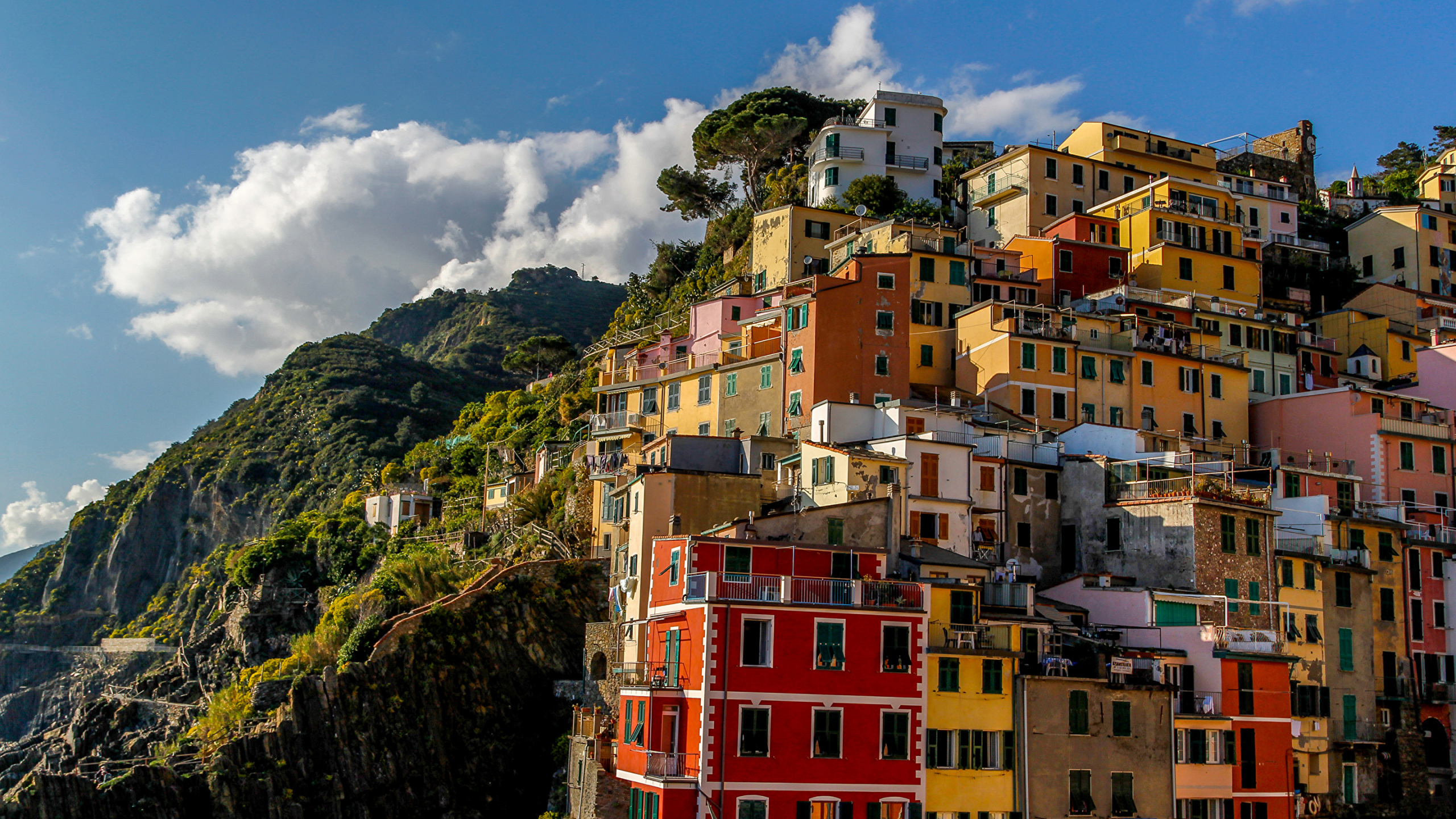 Yellow Red and White Concrete Buildings on Mountain Under Blue Sky and White Clouds During Daytime. Wallpaper in 2560x1440 Resolution