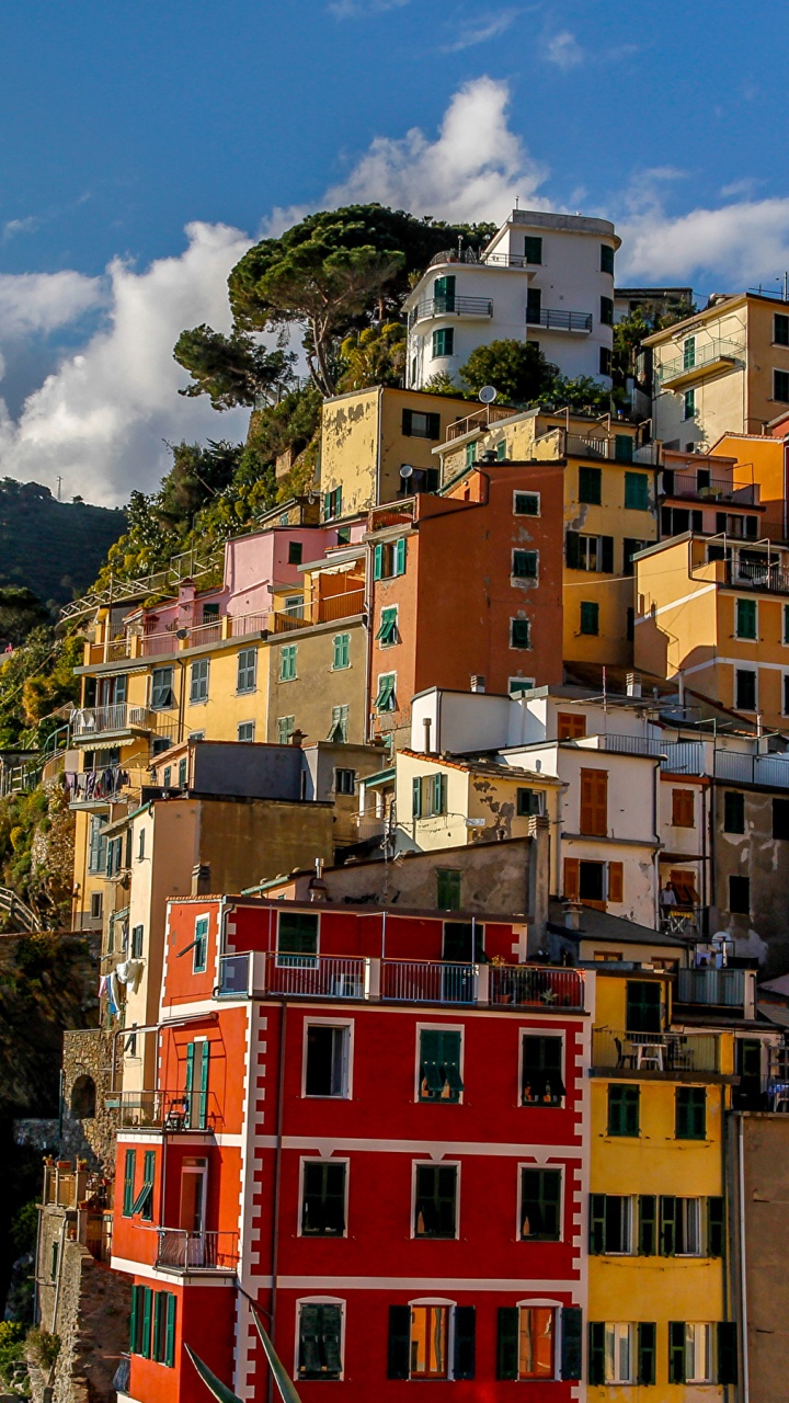 Yellow Red and White Concrete Buildings on Mountain Under Blue Sky and White Clouds During Daytime. Wallpaper in 720x1280 Resolution
