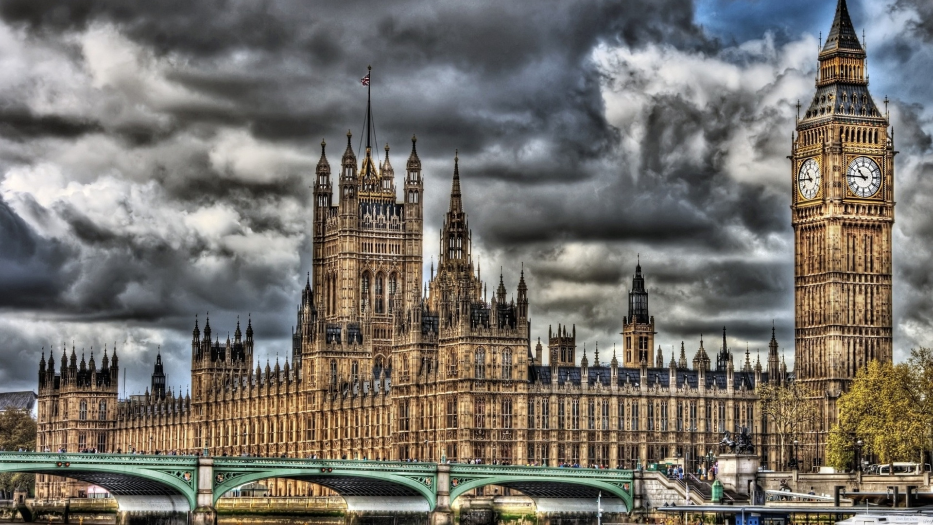 Green and White Cars on Road Near Brown Concrete Building Under Gray Clouds. Wallpaper in 1920x1080 Resolution
