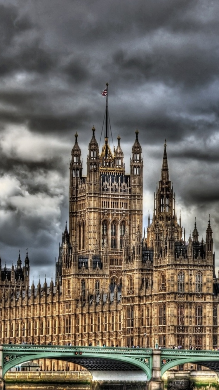 Green and White Cars on Road Near Brown Concrete Building Under Gray Clouds. Wallpaper in 750x1334 Resolution
