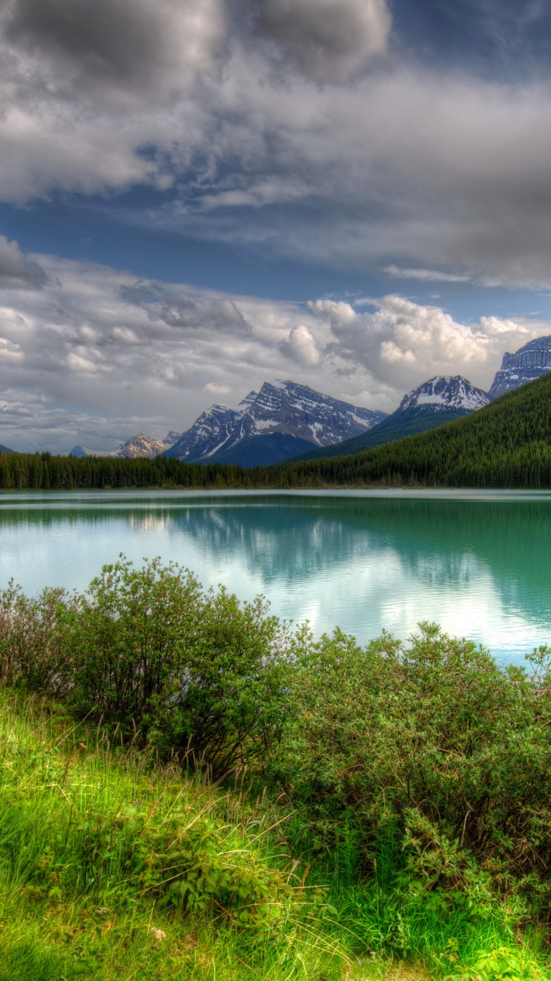 Green Grass Field Near Lake Under Cloudy Sky During Daytime. Wallpaper in 1080x1920 Resolution