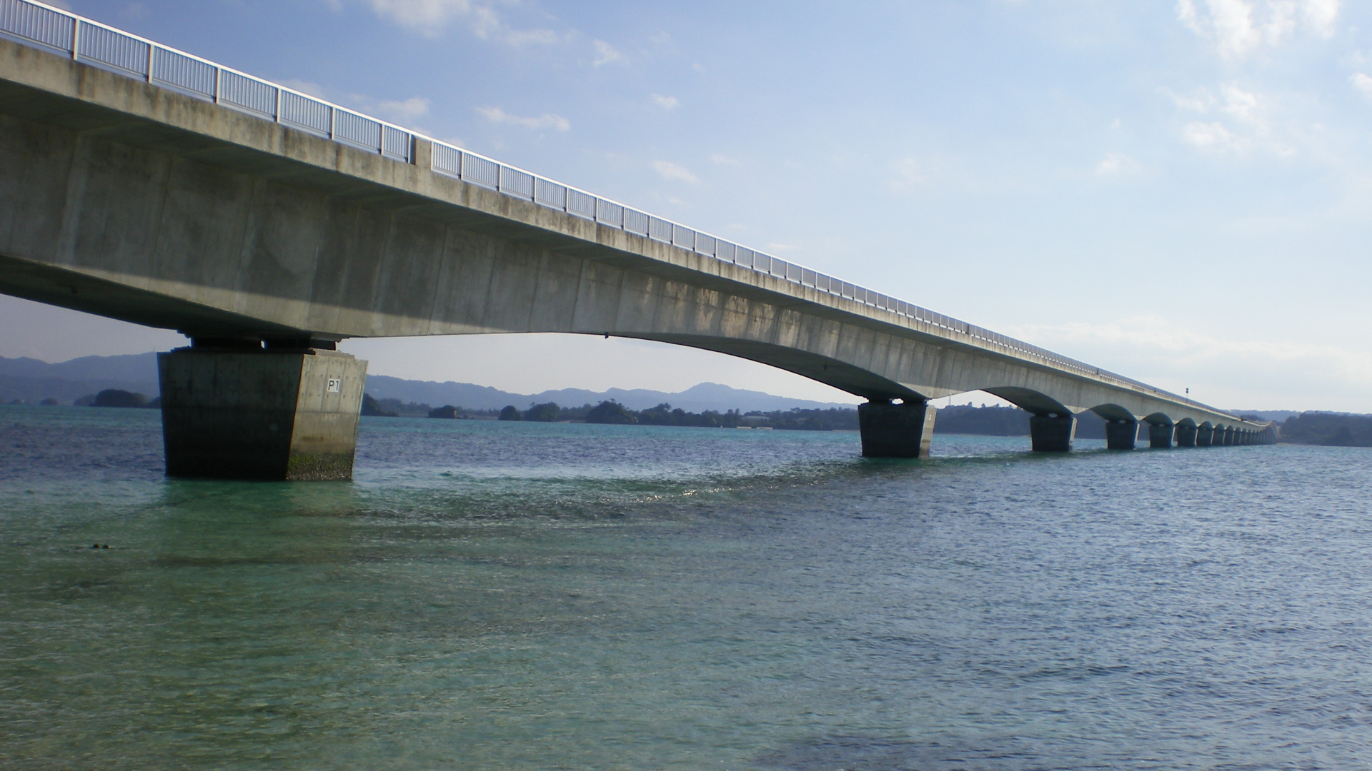Graue Betonbrücke Über Dem Meer Unter Weißen Wolken Tagsüber. Wallpaper in 1920x1080 Resolution