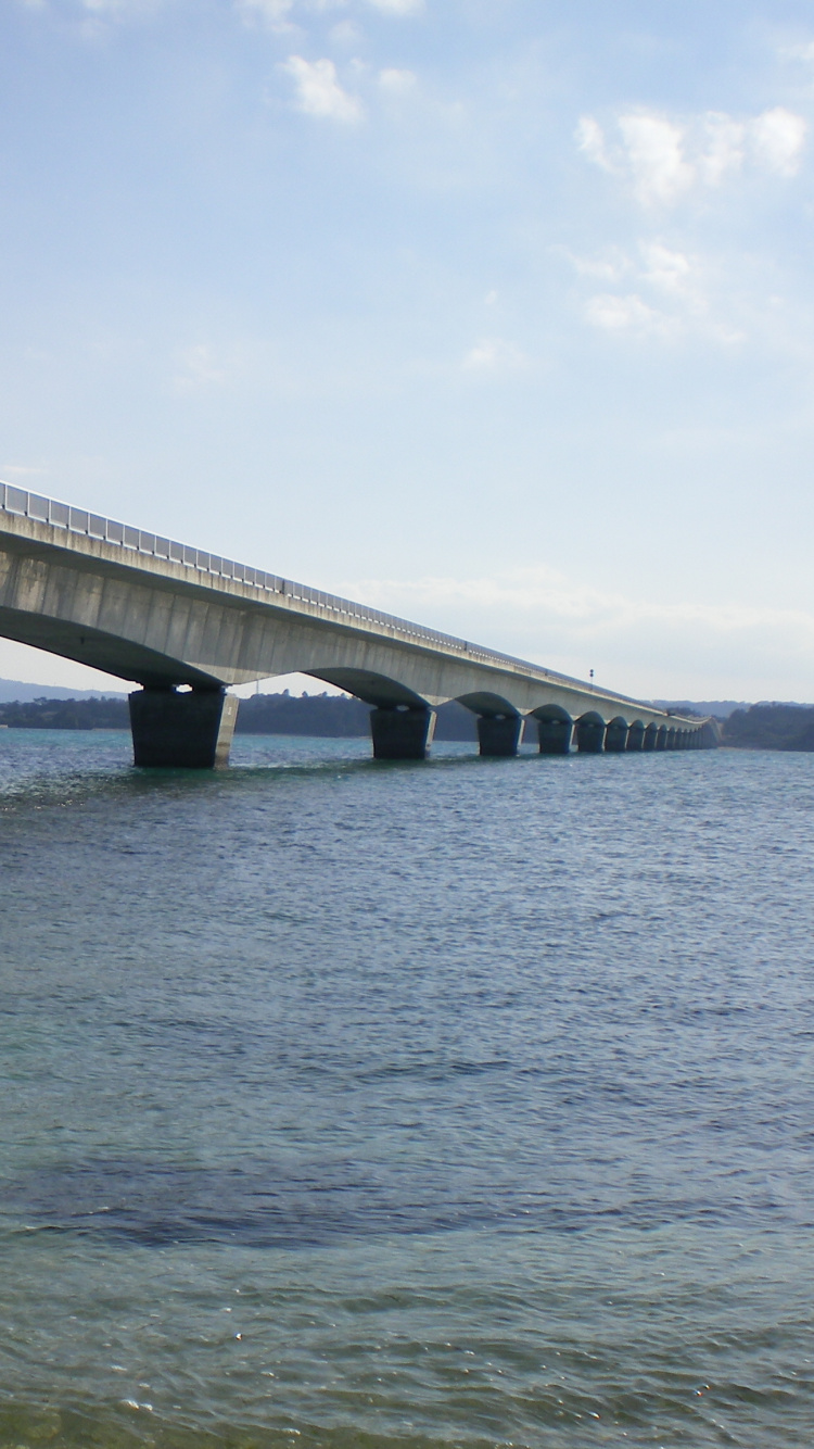 Pont en Béton Gris Au-dessus de la Mer Sous Des Nuages Blancs Pendant la Journée. Wallpaper in 750x1334 Resolution