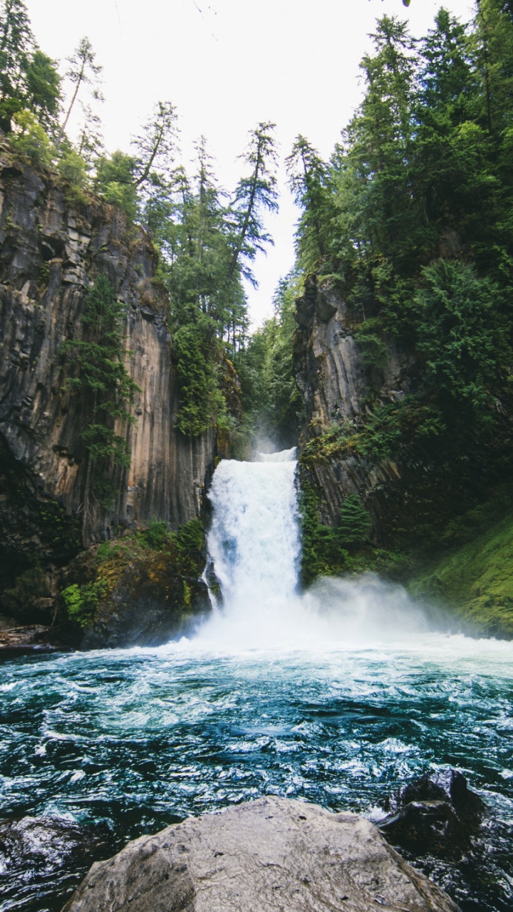 Water Falls Between Rocky Mountain During Daytime. Wallpaper in 720x1280 Resolution