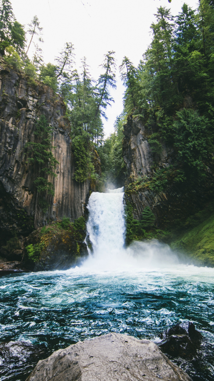 Water Falls Between Rocky Mountain During Daytime. Wallpaper in 750x1334 Resolution