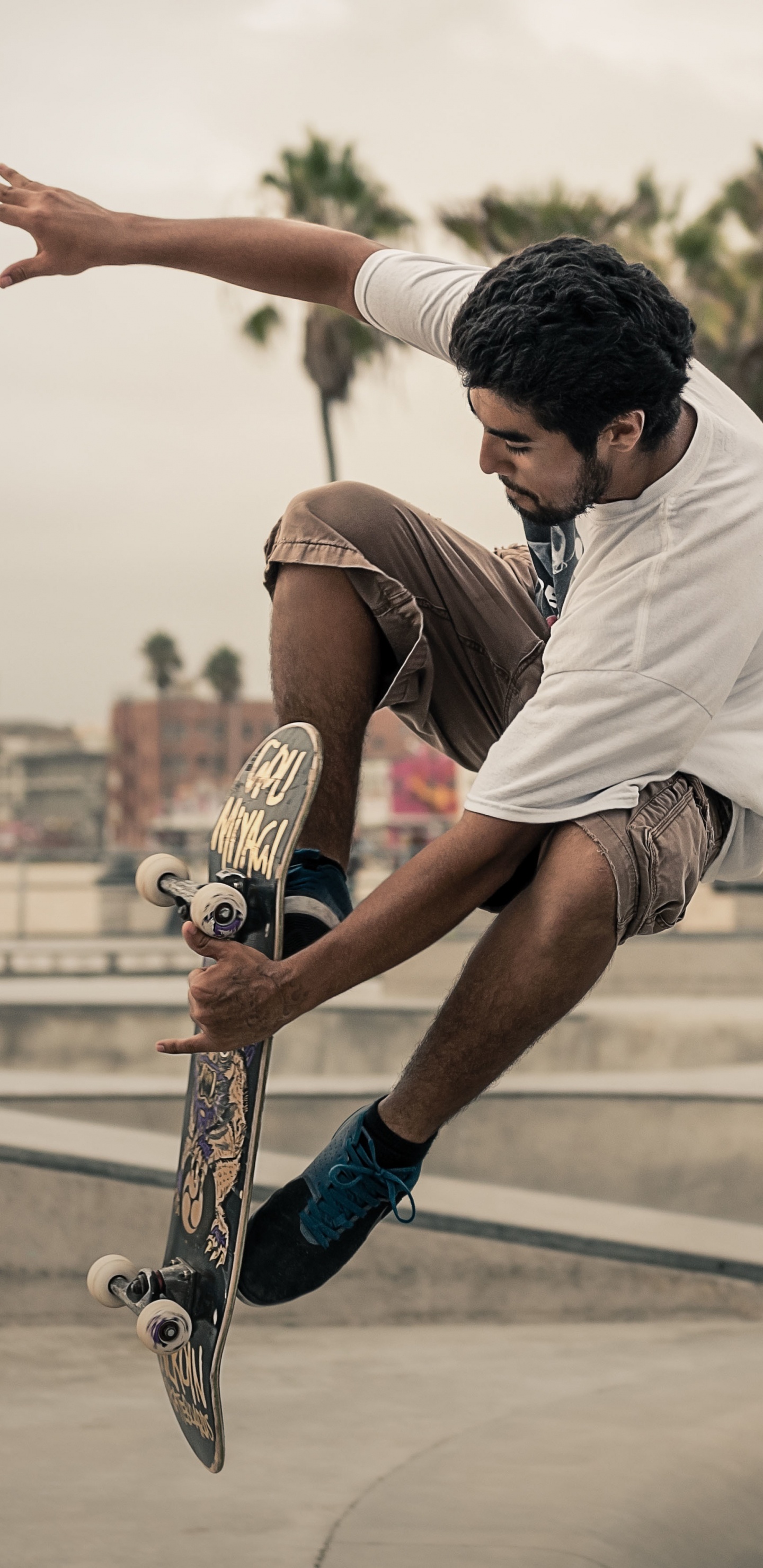 Mann in Weißem T-Shirt Und Braunen Shorts, Der Tagsüber Skateboard Spielt. Wallpaper in 1440x2960 Resolution