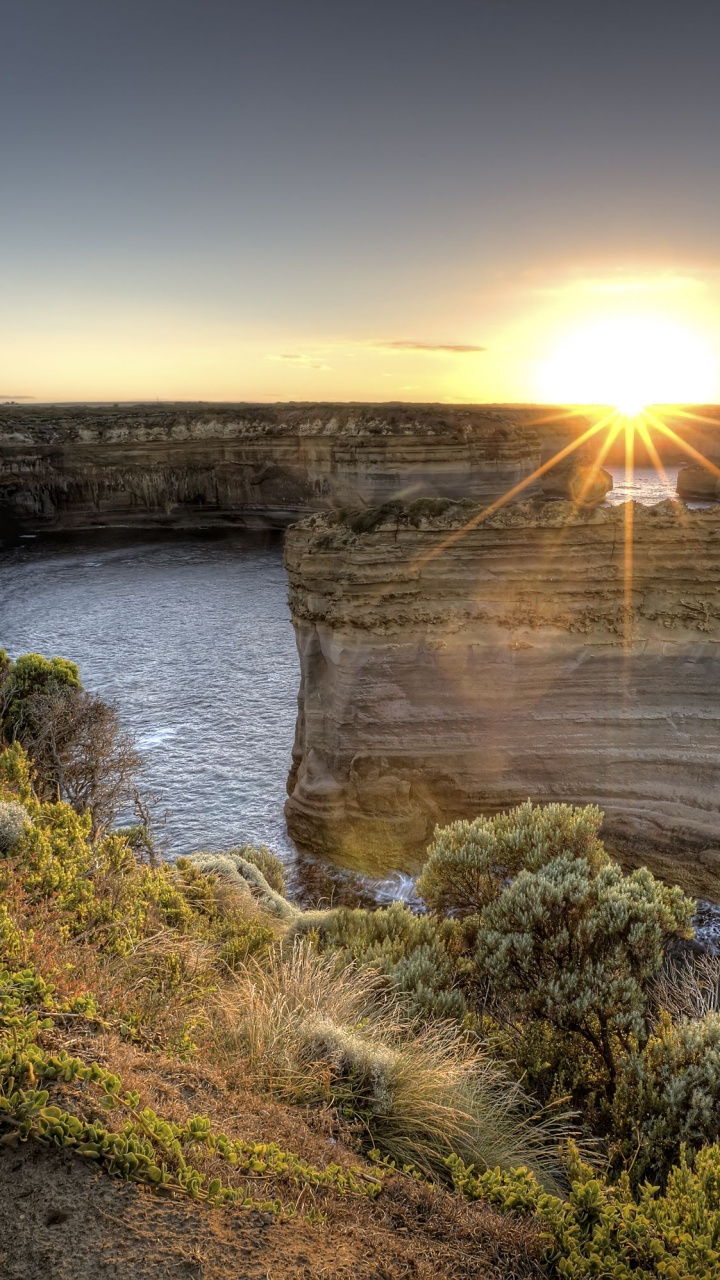 Montaña Rocosa Marrón Junto al Cuerpo de Agua Durante la Puesta de Sol. Wallpaper in 720x1280 Resolution