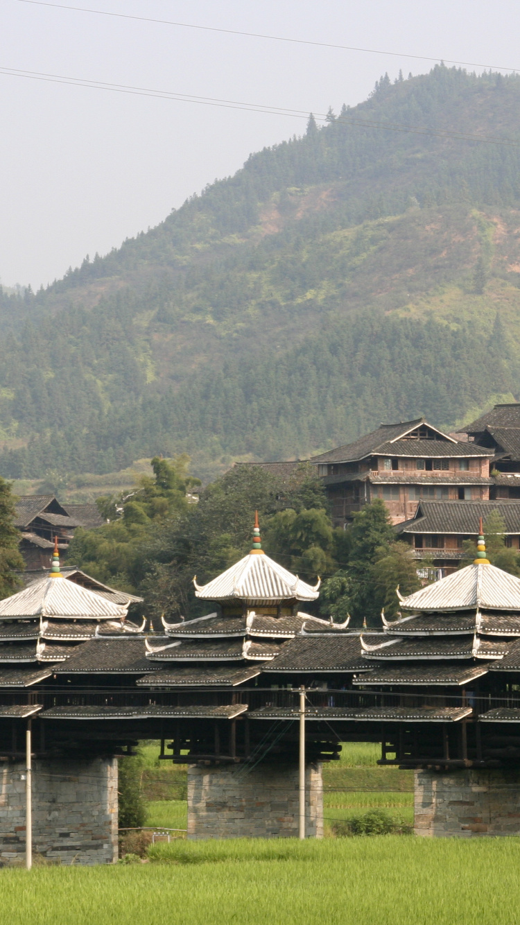Brown Wooden House on Green Grass Field Near Green Mountains During Daytime. Wallpaper in 750x1334 Resolution