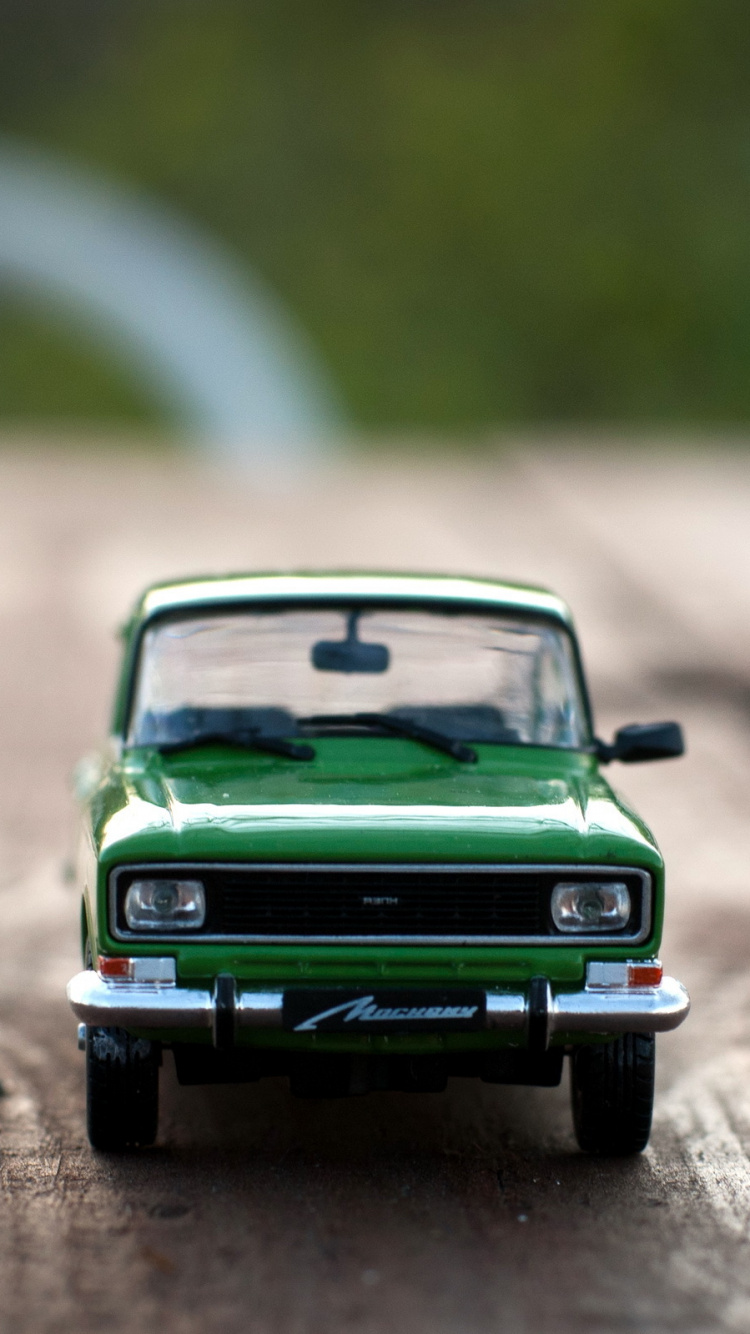 Modelo a Escala de Coche Verde en la Carretera. Wallpaper in 750x1334 Resolution
