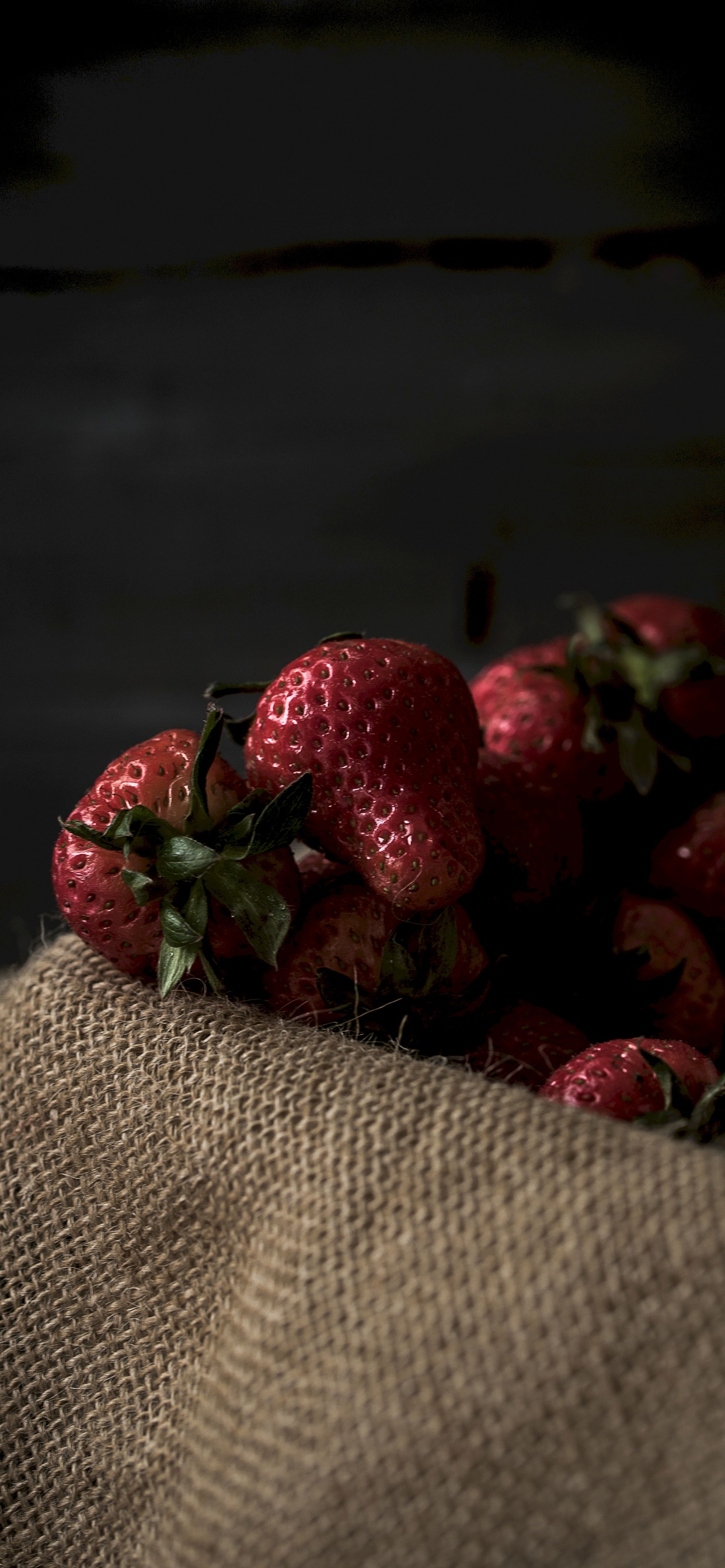 Rote Erdbeeren Auf Braunem Textil. Wallpaper in 1242x2688 Resolution