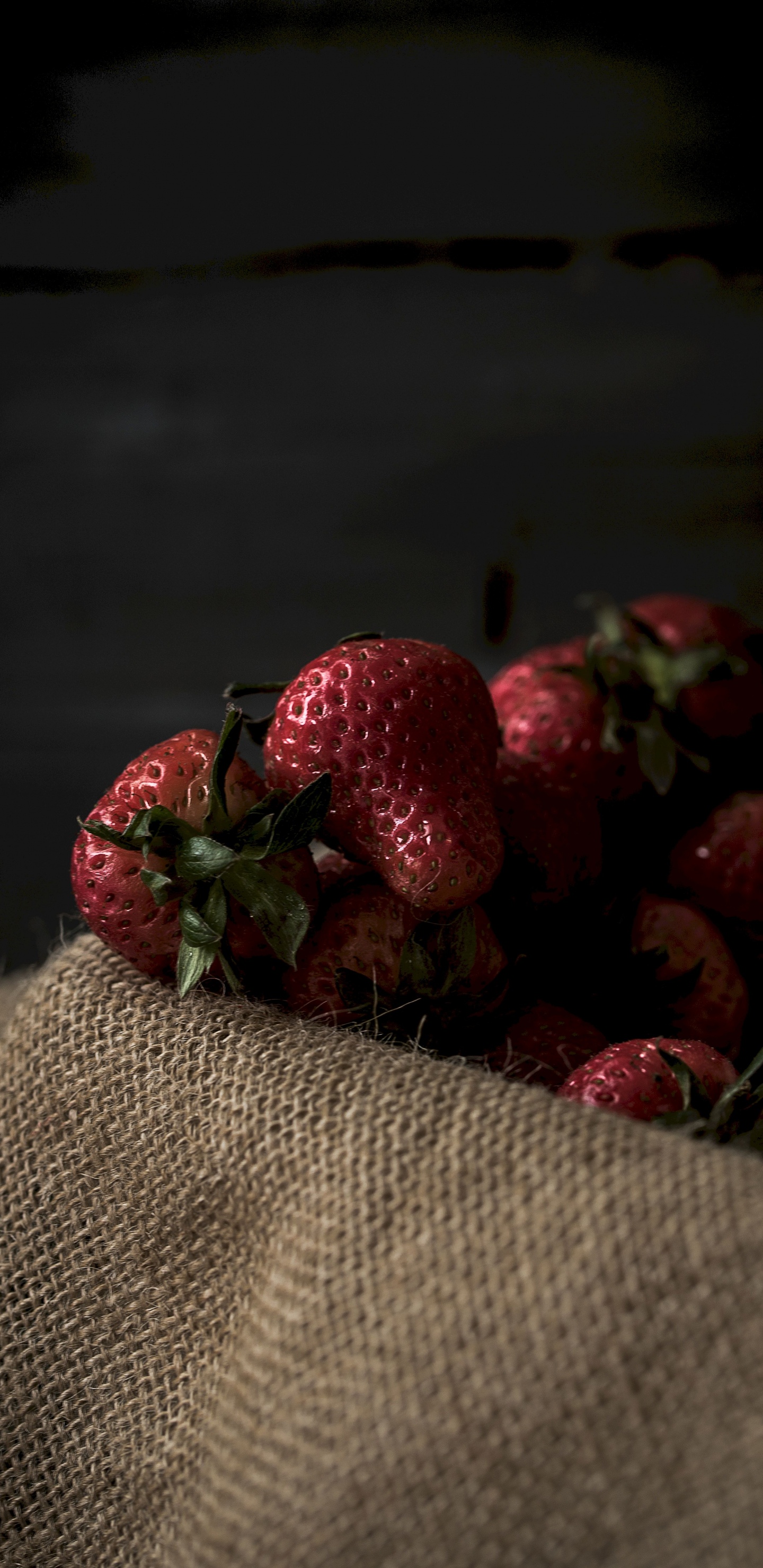 Rote Erdbeeren Auf Braunem Textil. Wallpaper in 1440x2960 Resolution