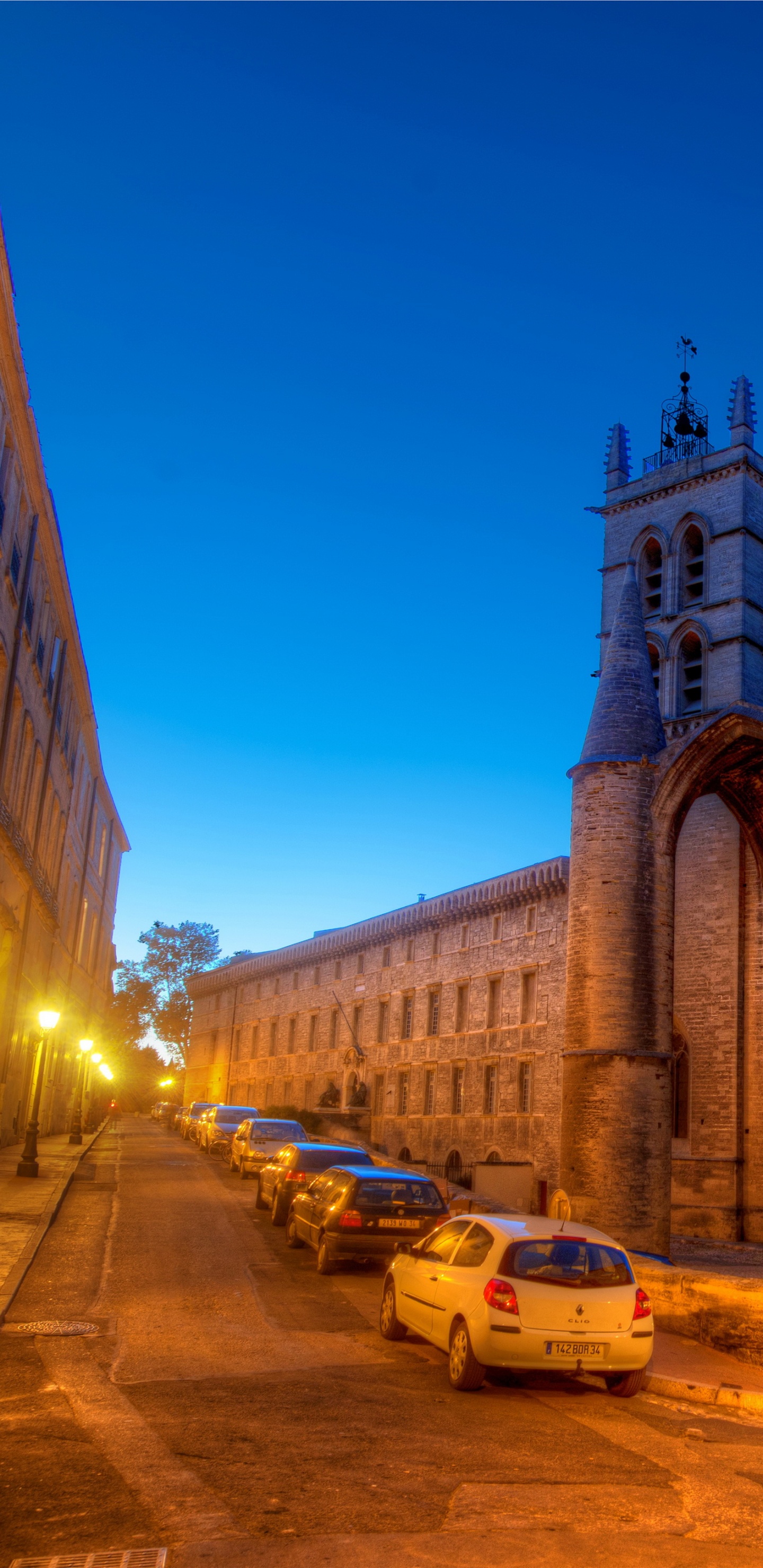 Coches Aparcados Junto a un Edificio de Hormigón Marrón Durante la Noche. Wallpaper in 1440x2960 Resolution