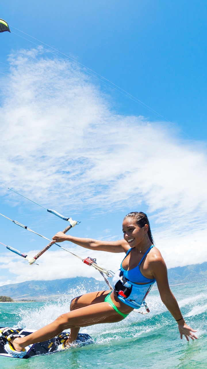 Frau in Blau-schwarzem Bikini-Oberteil Und Blauen Shorts, Die Tagsüber Auf Den Wellen Des Meeres Surft. Wallpaper in 720x1280 Resolution