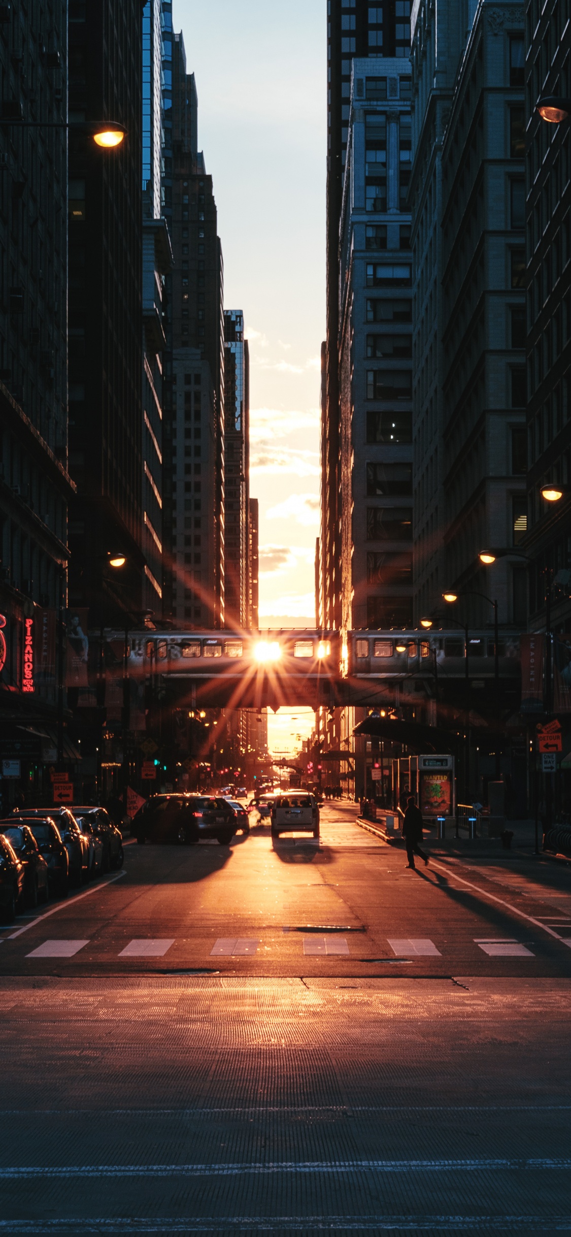 Coches en la Carretera Entre Edificios de Gran Altura Durante la Noche. Wallpaper in 1125x2436 Resolution