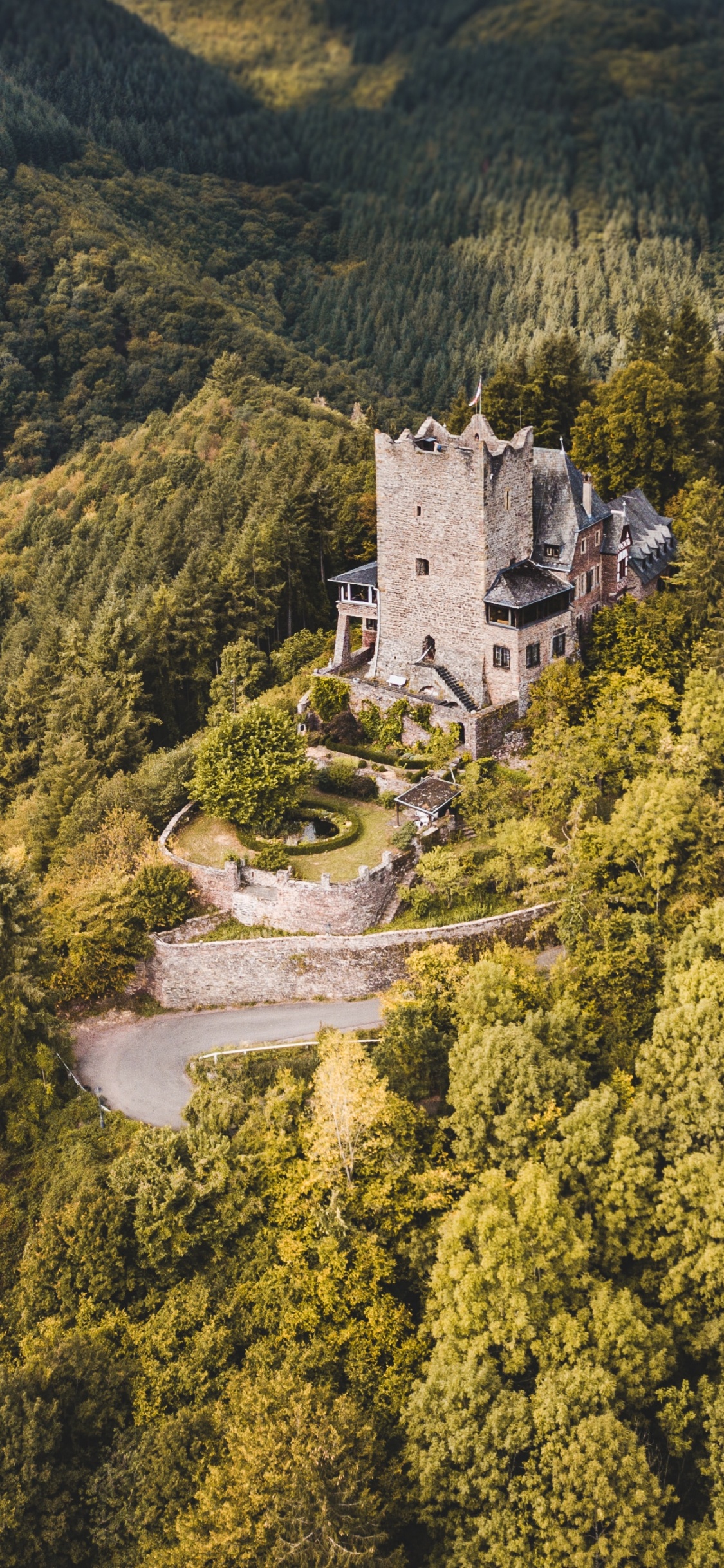 Château en Béton Blanc Sur la Montagne Verte Pendant la Journée. Wallpaper in 1125x2436 Resolution