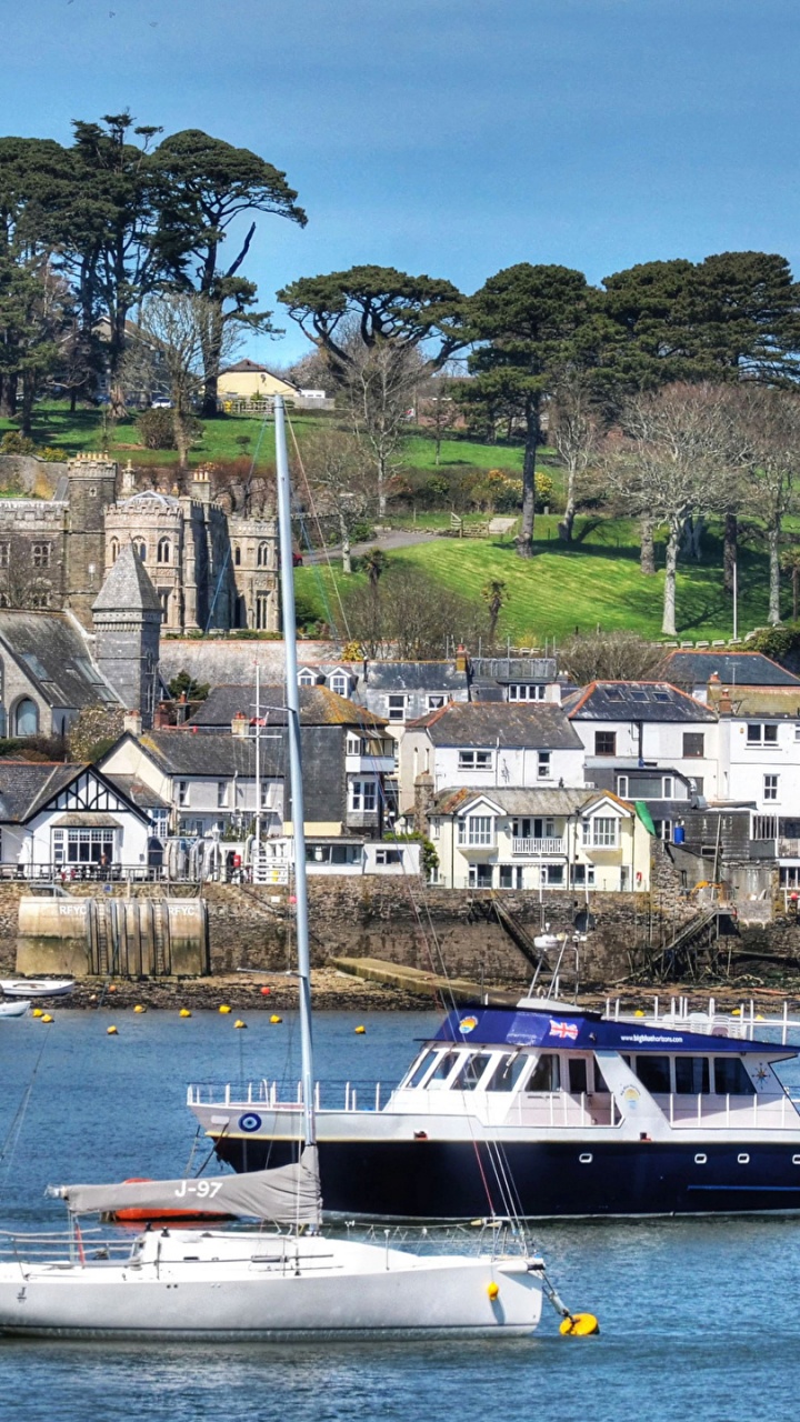 Bateau Blanc et Bleu Sur la Mer Près D'un Bâtiment en Béton Brun Pendant la Journée. Wallpaper in 720x1280 Resolution