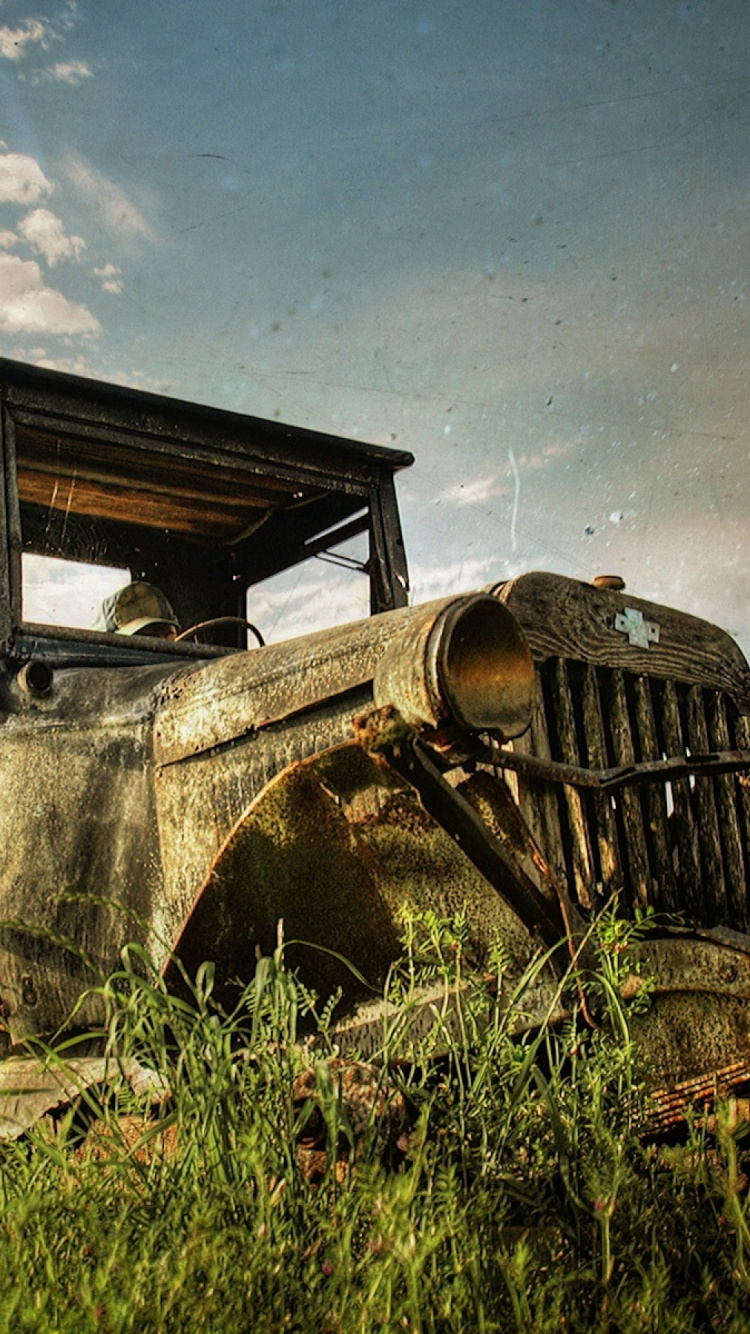 Vintage Car on Green Grass Field Under Cloudy Sky. Wallpaper in 750x1334 Resolution