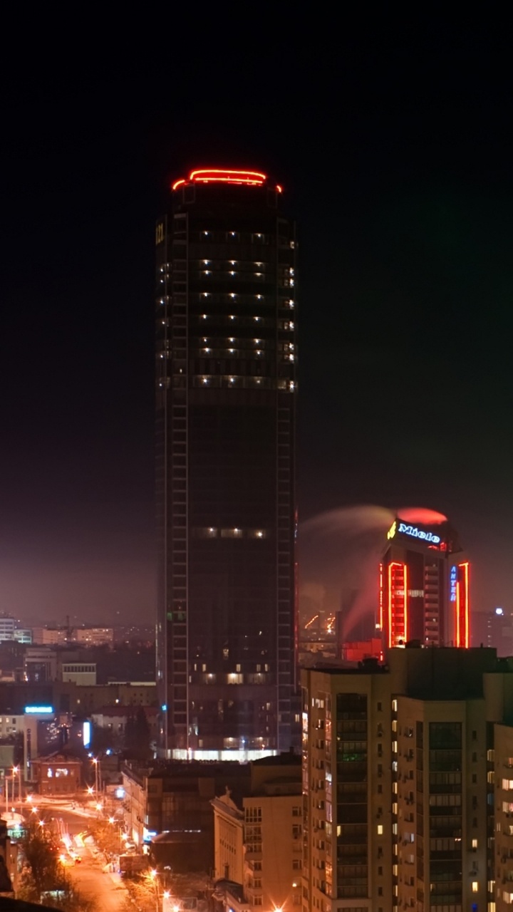 City Skyline With Lights Turned on During Night Time. Wallpaper in 720x1280 Resolution