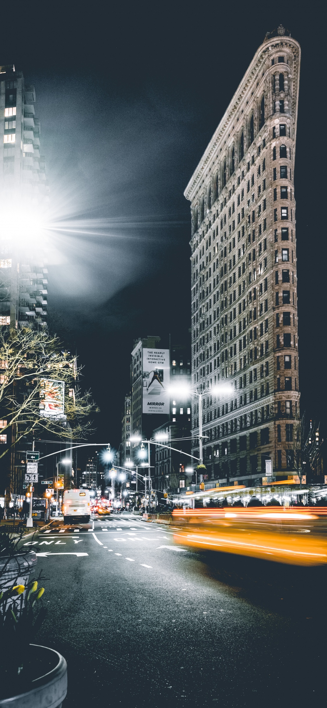 Cars on Road Near High Rise Buildings During Night Time. Wallpaper in 1125x2436 Resolution