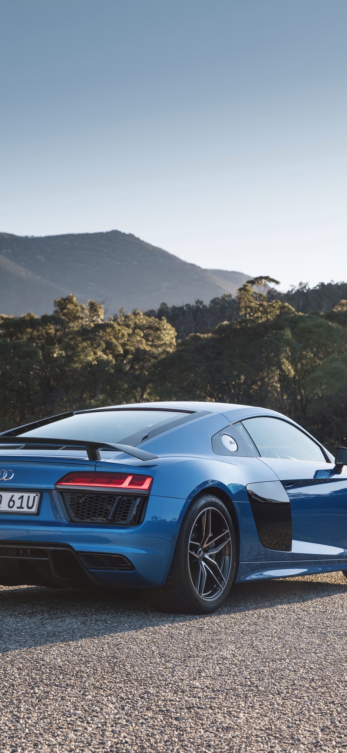 Blue Porsche 911 on Gray Dirt Road During Daytime. Wallpaper in 1125x2436 Resolution