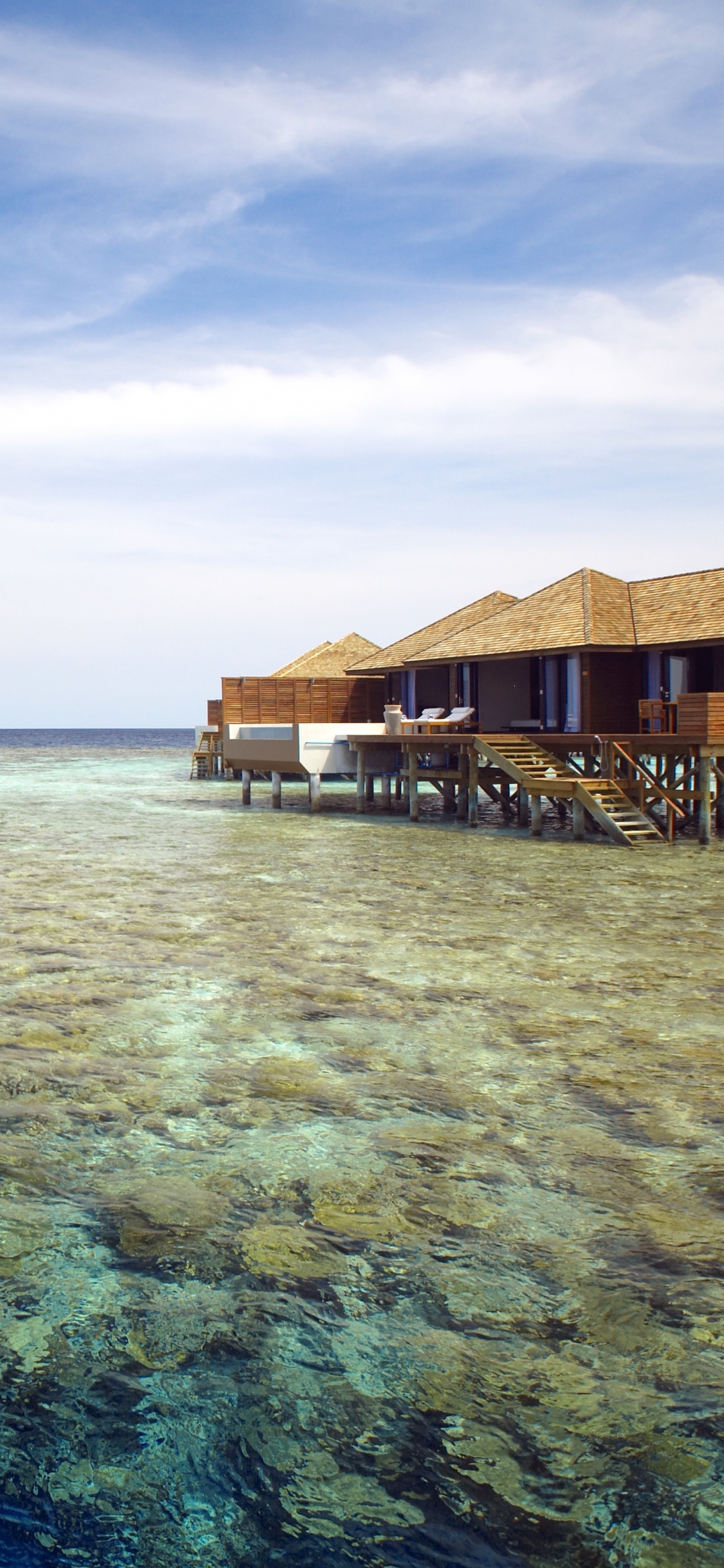 Brown Wooden House on Body of Water Under Blue Sky During Daytime. Wallpaper in 1125x2436 Resolution