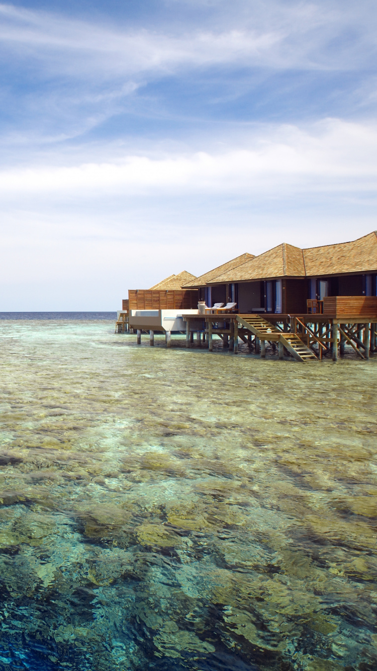 Brown Wooden House on Body of Water Under Blue Sky During Daytime. Wallpaper in 750x1334 Resolution