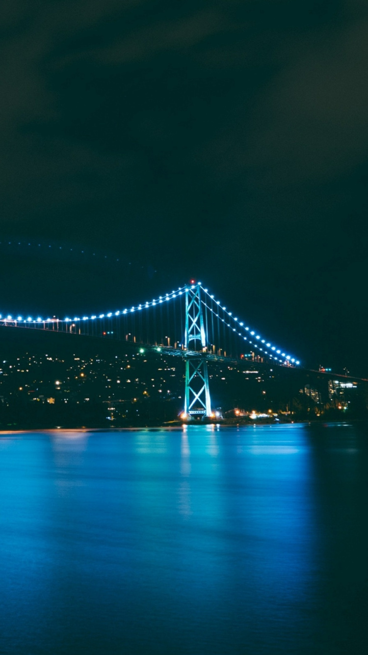 Lighted Bridge Over Water During Night Time. Wallpaper in 750x1334 Resolution