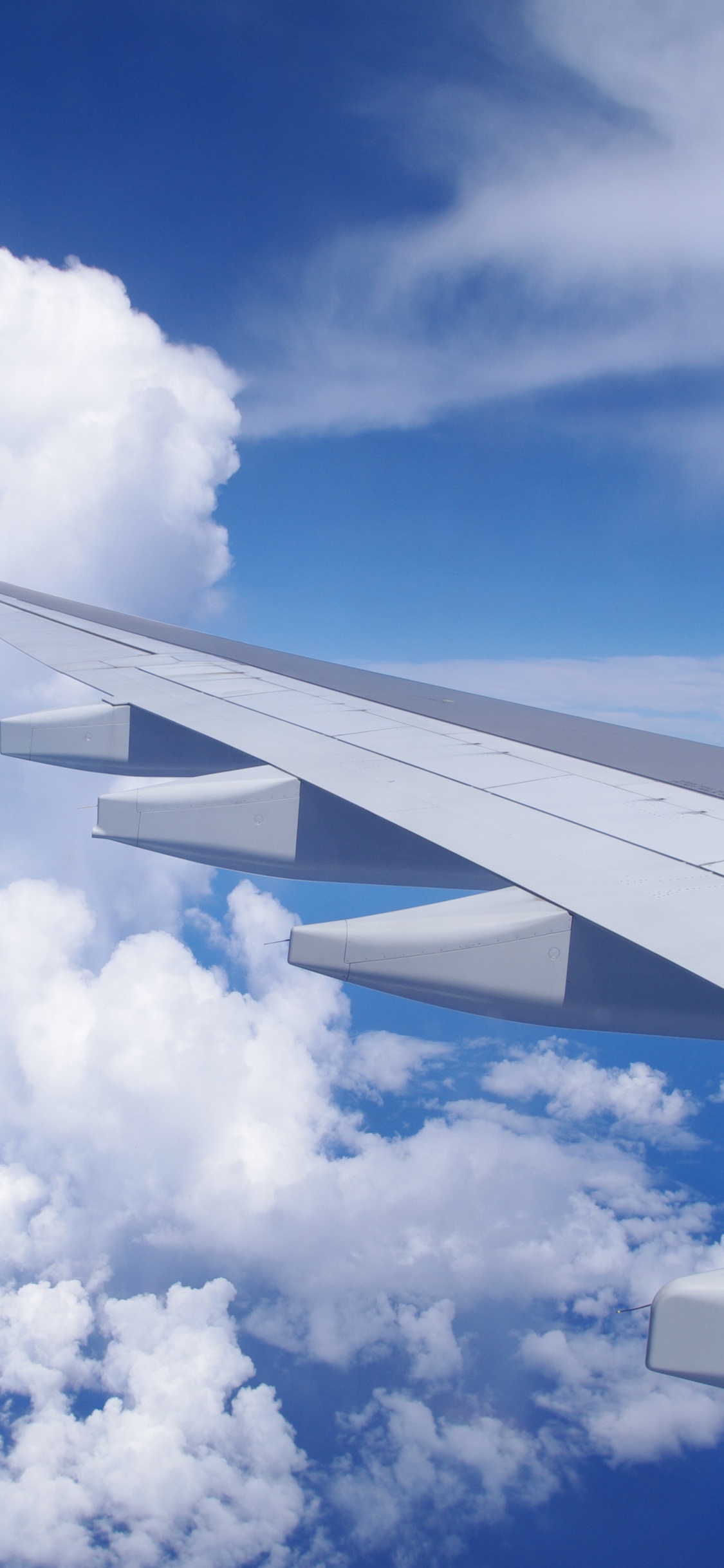 White and Red Airplane Wing Under Blue Sky and White Clouds During Daytime. Wallpaper in 1125x2436 Resolution