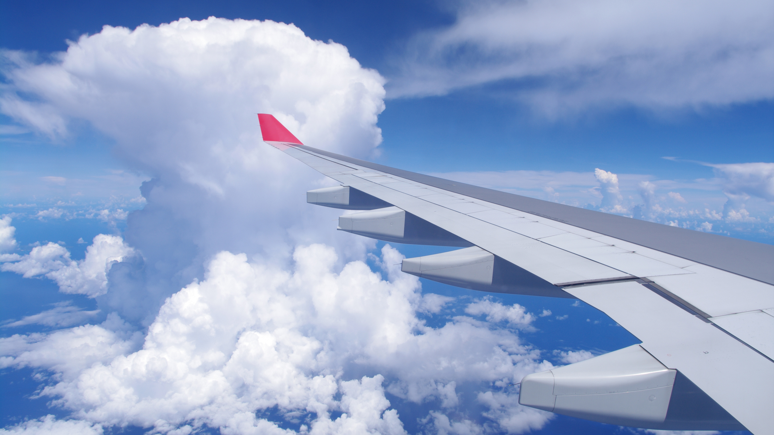 White and Red Airplane Wing Under Blue Sky and White Clouds During Daytime. Wallpaper in 2560x1440 Resolution